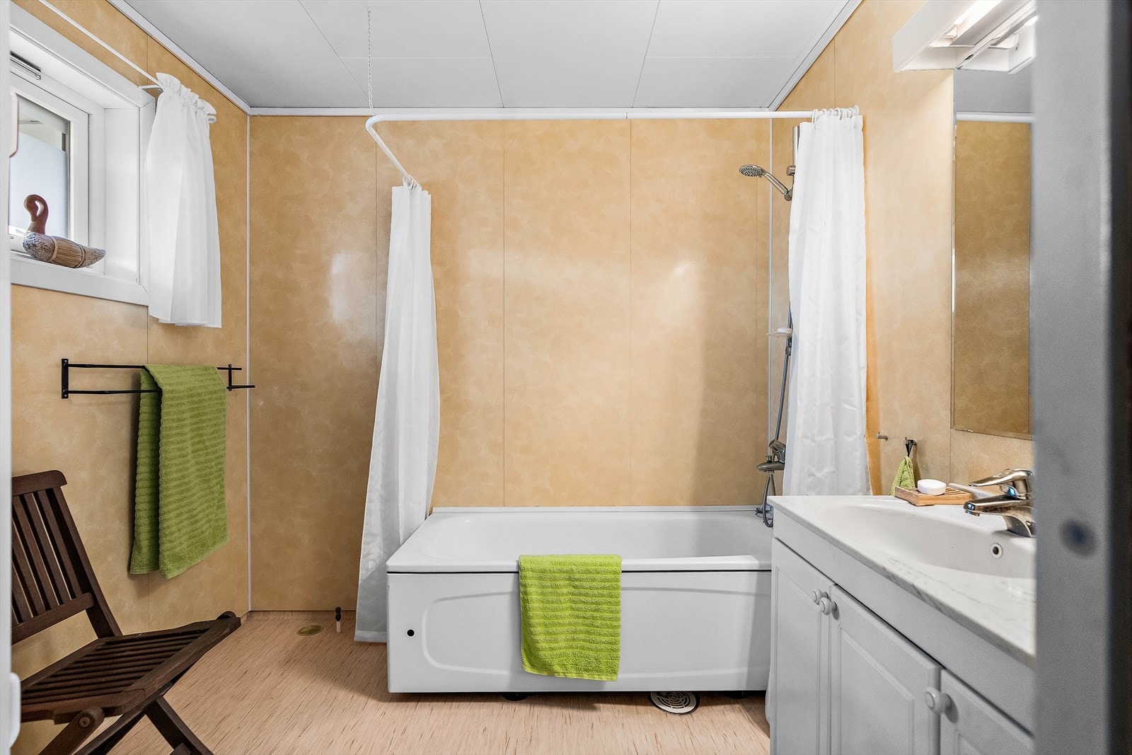 Baderom med baderomsplater på vegger og vinylbelegg på gulv. Galleribilde