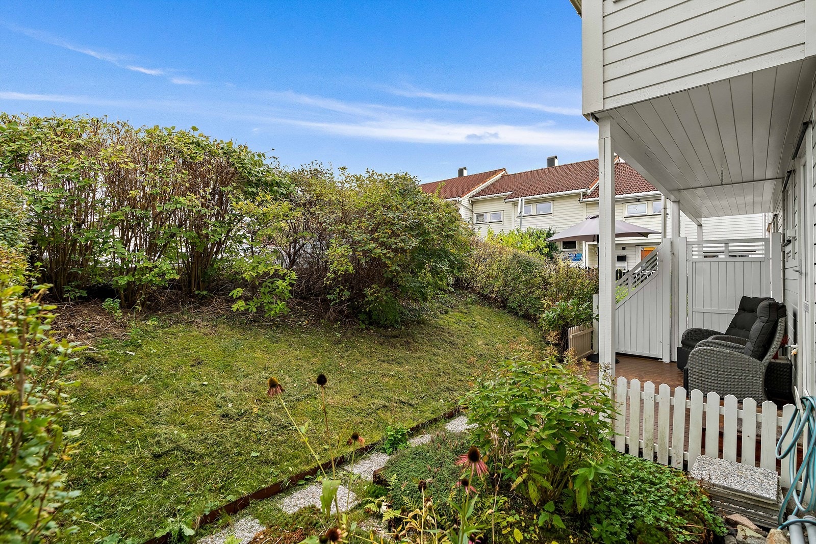 Skjermet terrasse med beplantning og levegg mot nabo. Galleribilde