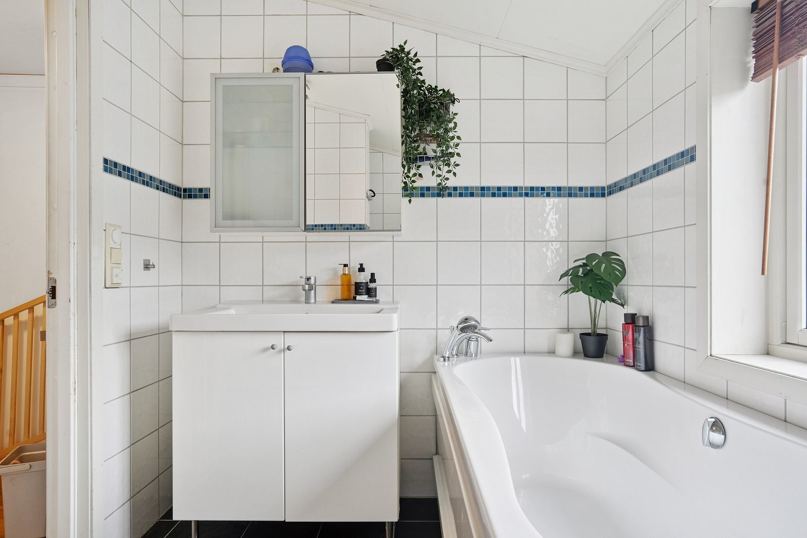 Lyst komplett flislagt bad med badekar.