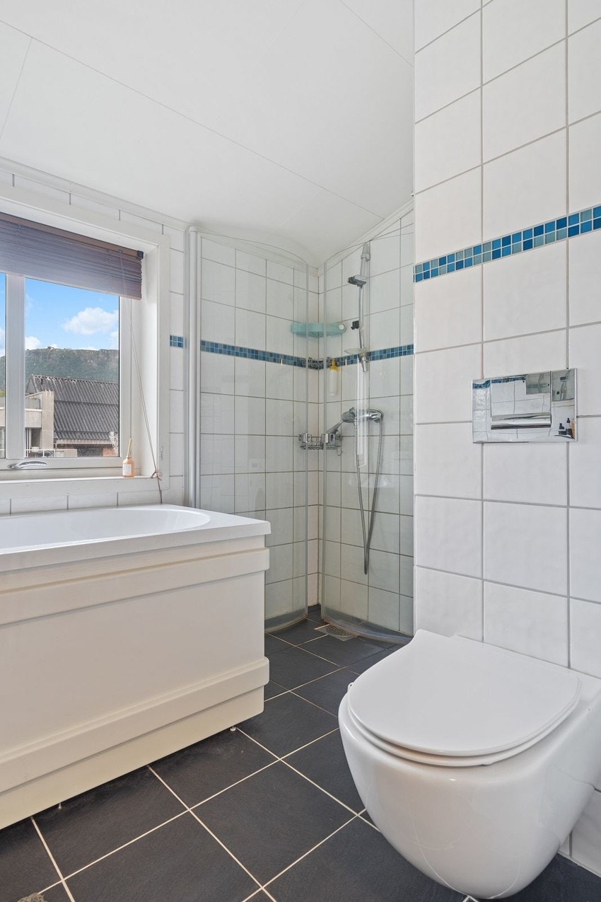 Badet har også hjørnedusj i tillegg til badekaret.