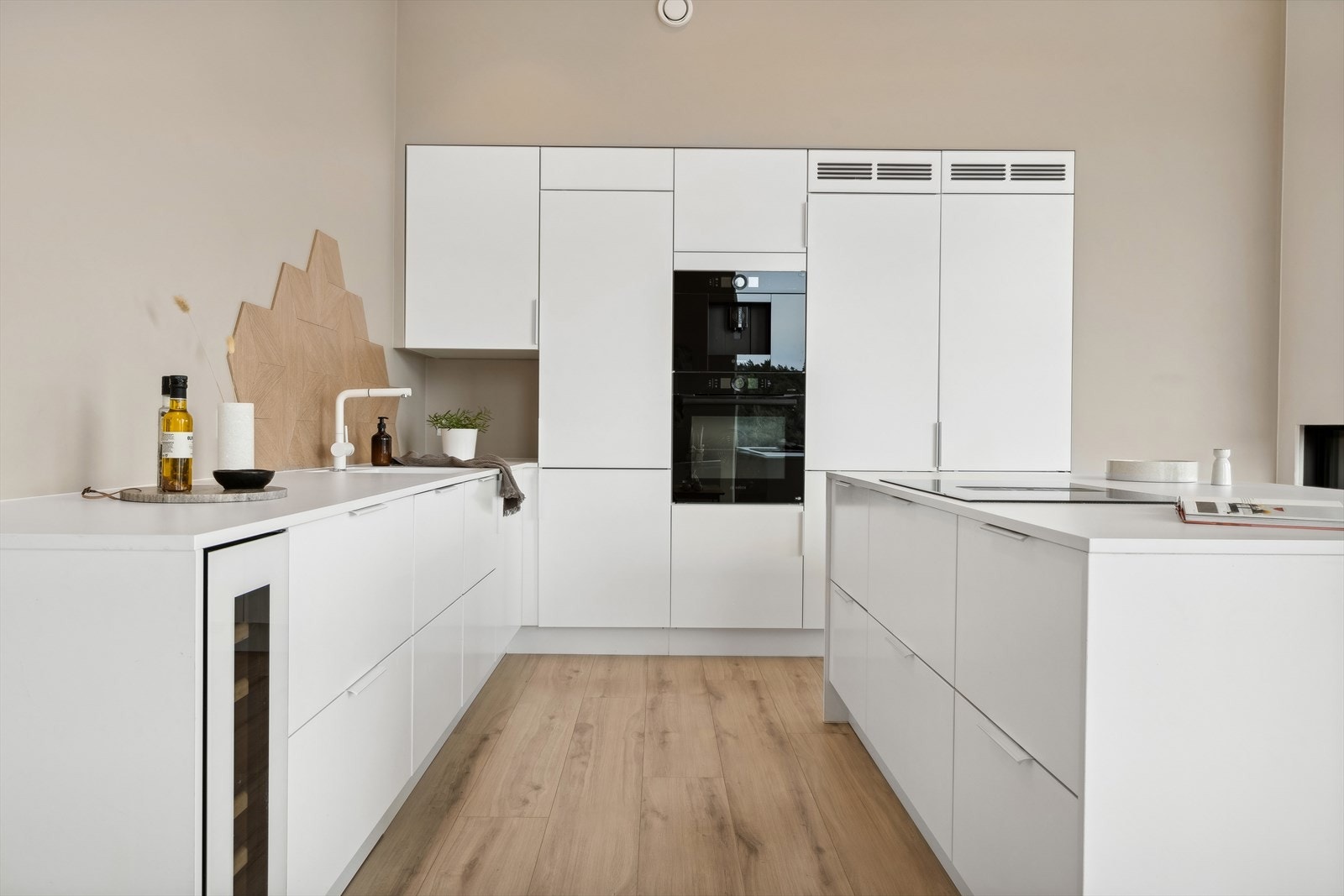 Det er laget til rom i sokkel for robotstøvsuger. Vinskap fra Temptech. Galleribilde