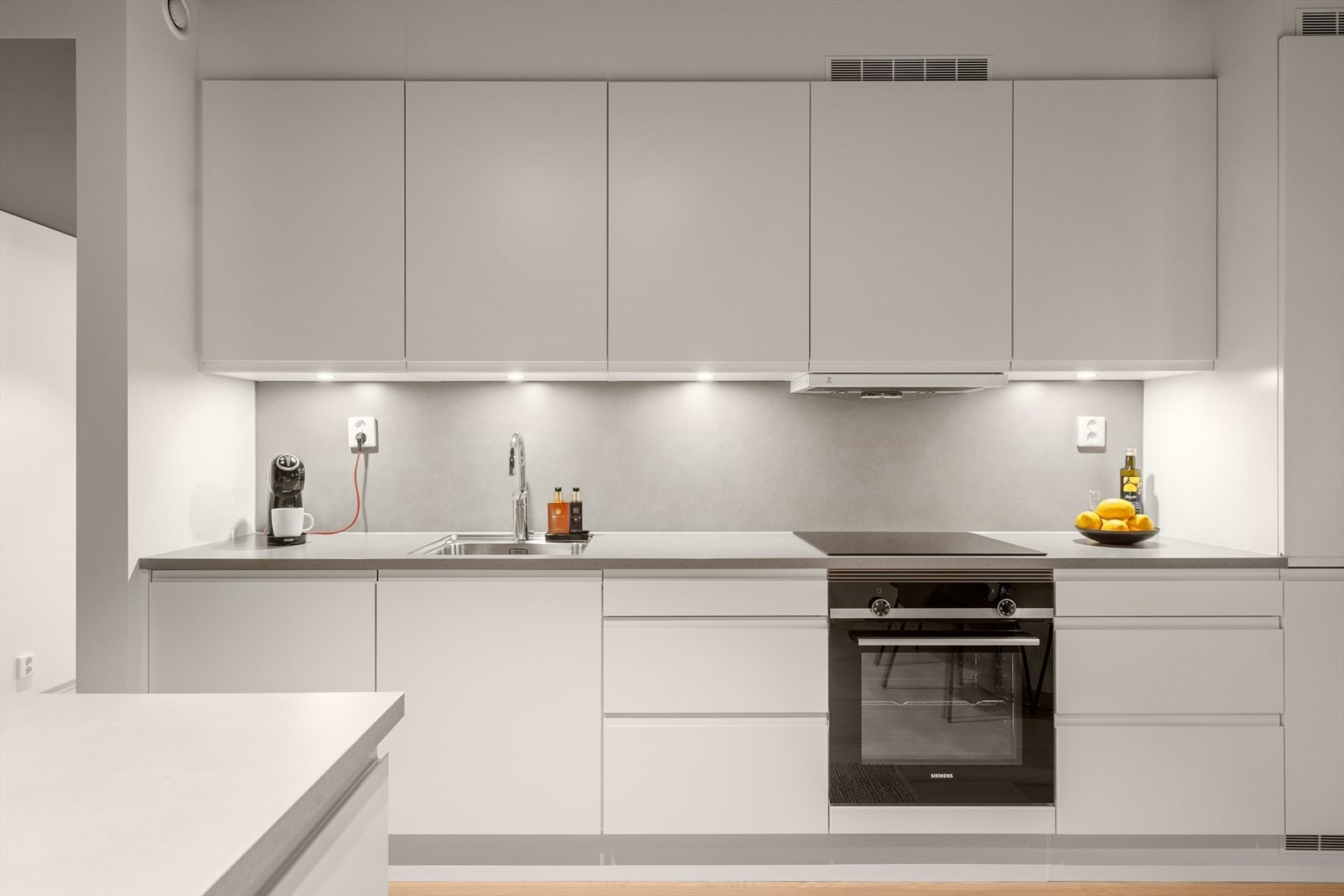 Det er spotter over benk, og fin benkeplate som går igjen mellom overskapene. Galleribilde