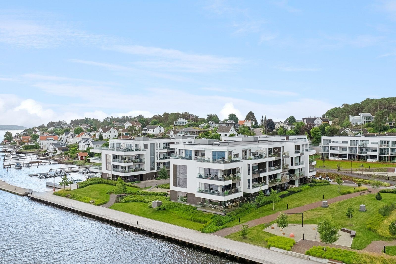 Dronebilde fra sommerstid. Det er umiddelbar nærhet til båthavn, badeplasser, lekeplasser og turstier. Galleribilde