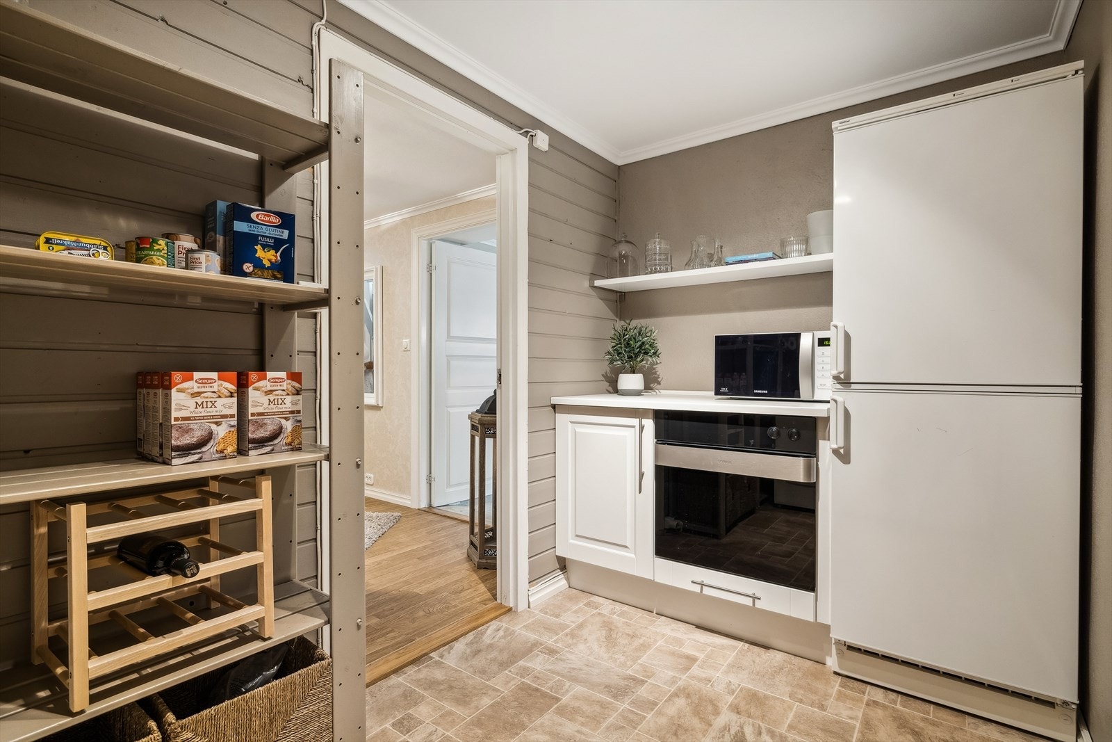 Fra trappegang i kjelleretasje er det dør til praktisk matbod, også innredet med hybelkjøkken Galleribilde