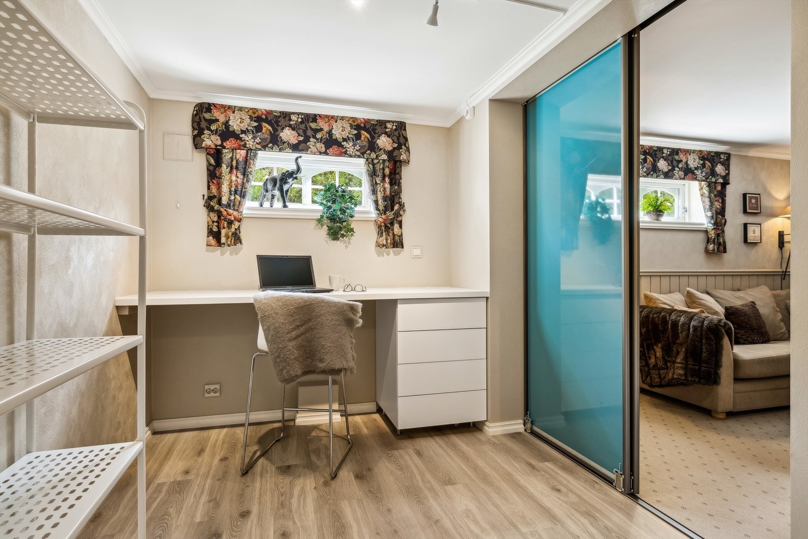 Hobbyrom i kjelleretasje innredet som kontor. Skyvedør inn til kjellerstue. Galleribilde