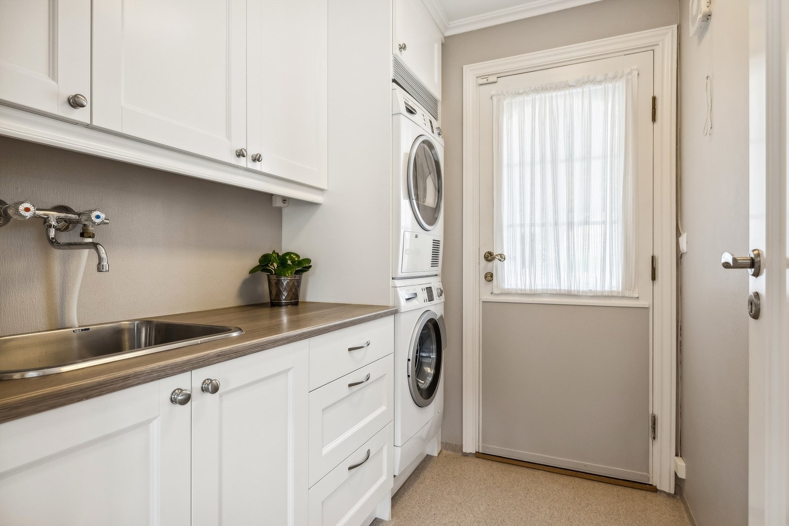 Praktisk vaskerom med kum og innredning. Dør direkte til inngangsparti og videre dør til kjøkken Galleribilde