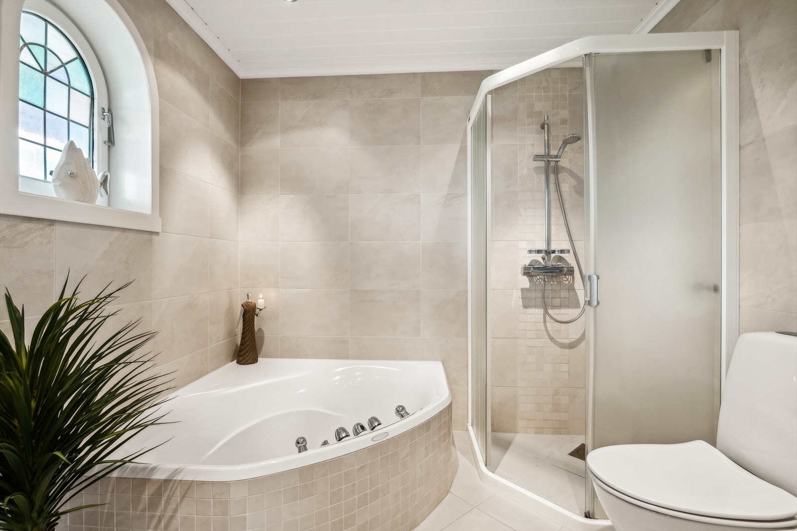 Baderom i første etasje med fliser på vegg og gulv. El-ventil i himling for ventilasjon. Hjørnekar og dusjnisje. Galleribilde