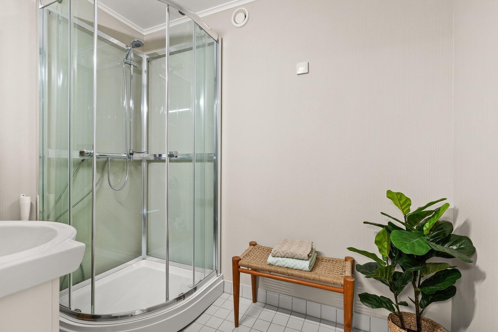 Badet består av dusjkabinett, servant med innredning og opplegg for vaskemaskin. Galleribilde