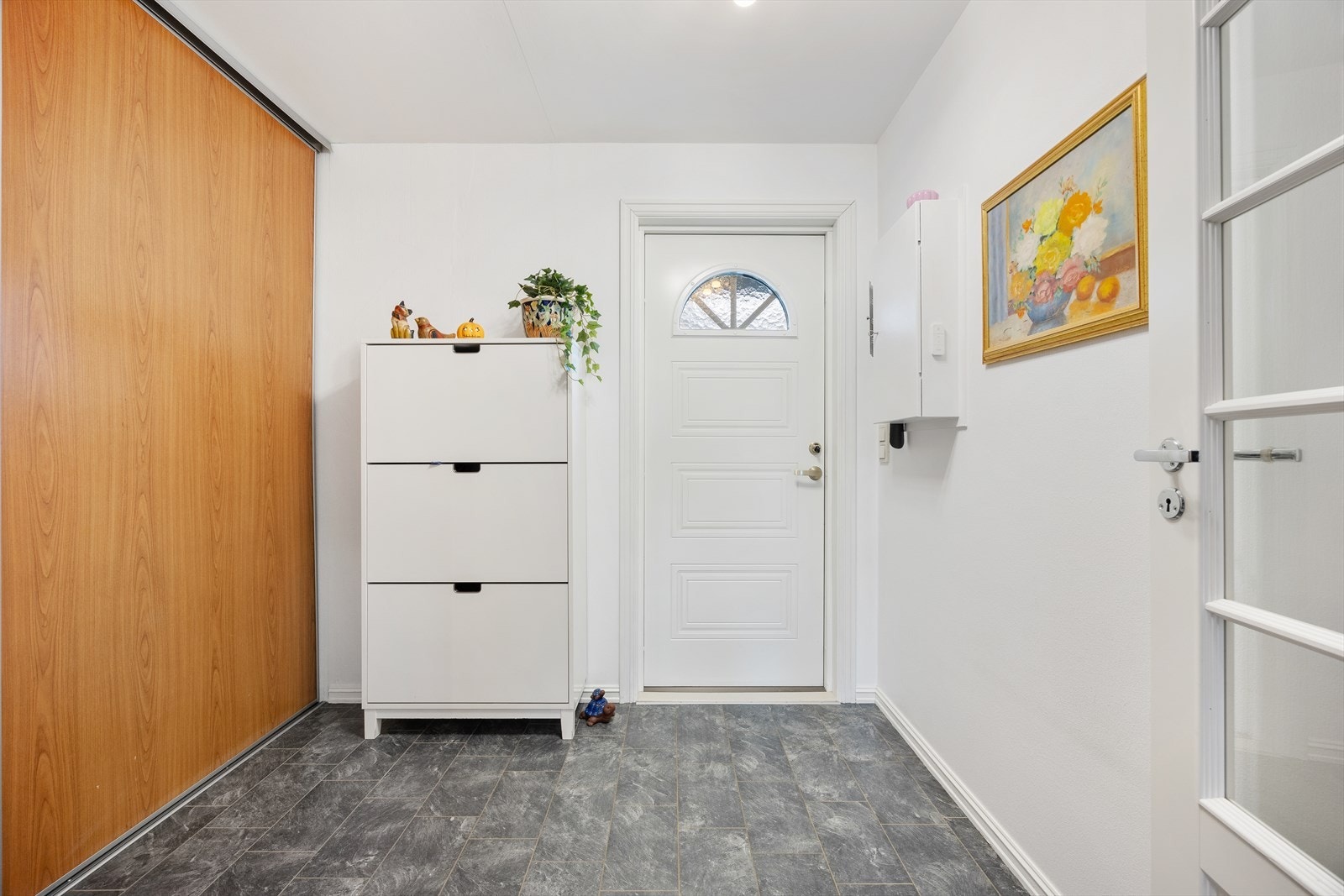 Velkommen inn i en praktisk entré med flislagt gulv og plass til oppbevaring. Galleribilde