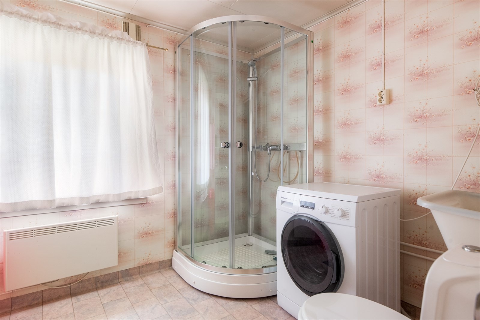 Badet er også innredet med dusjkabinett og toalett, samt skyllekum og opplegg for vaskemaskin. Badet har panelovn som varmekilde. Galleribilde
