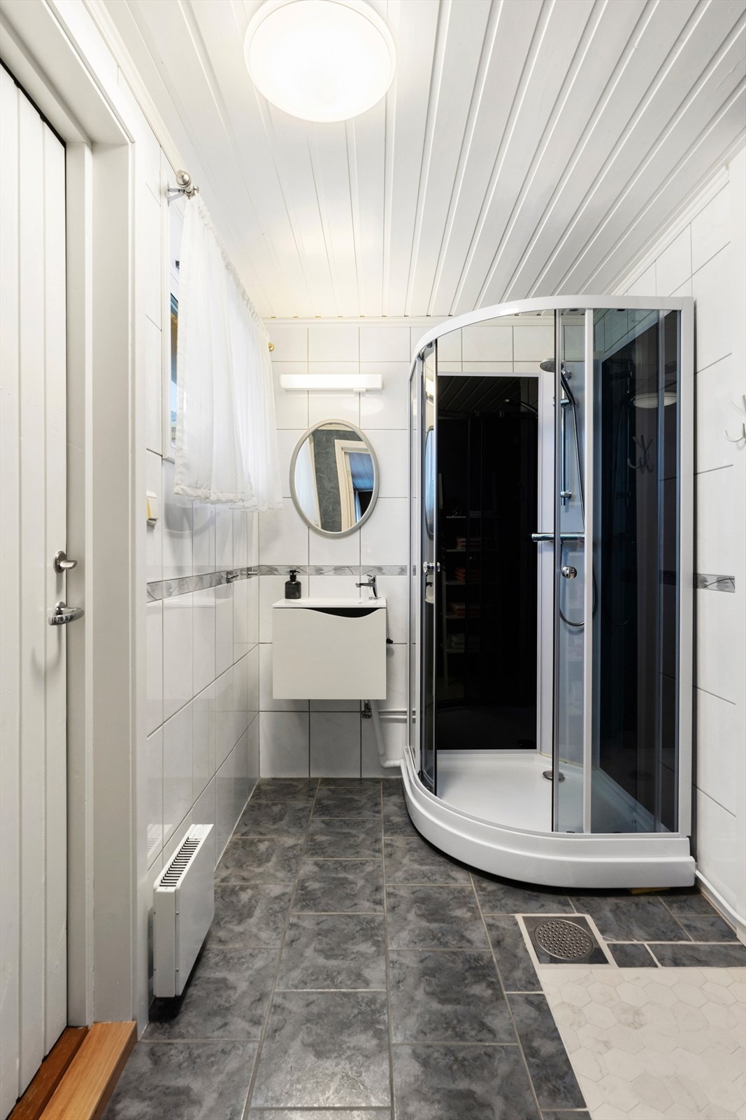 Bad 2 har flislagte gulv og vegger i våtsonen, samt dusjkabinett og panelovn som varmekilde. Galleribilde