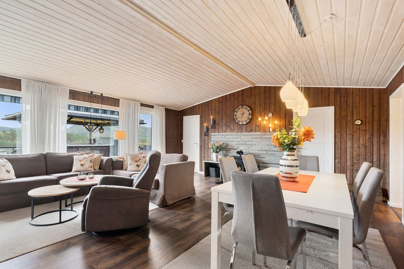 Stuen har en åpen løsning med spiseplass og vedovn, ideelt for sosiale sammenkomster. Galleribilde