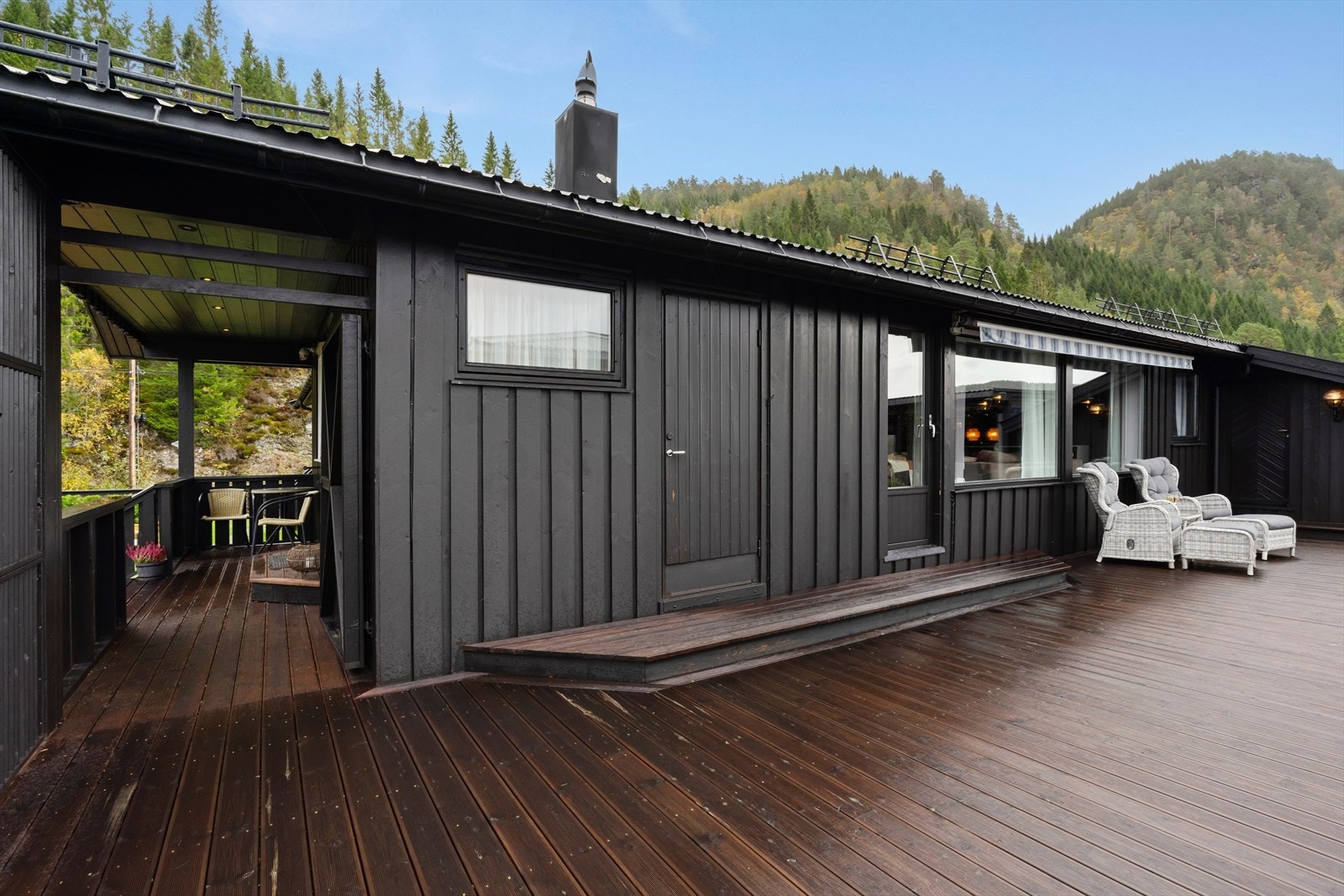 Terrassen strekker seg rundt boligen og tilbyr en hyggelig uteplass med direkte adkomst fra både stuen og inngangspartiet. Galleribilde