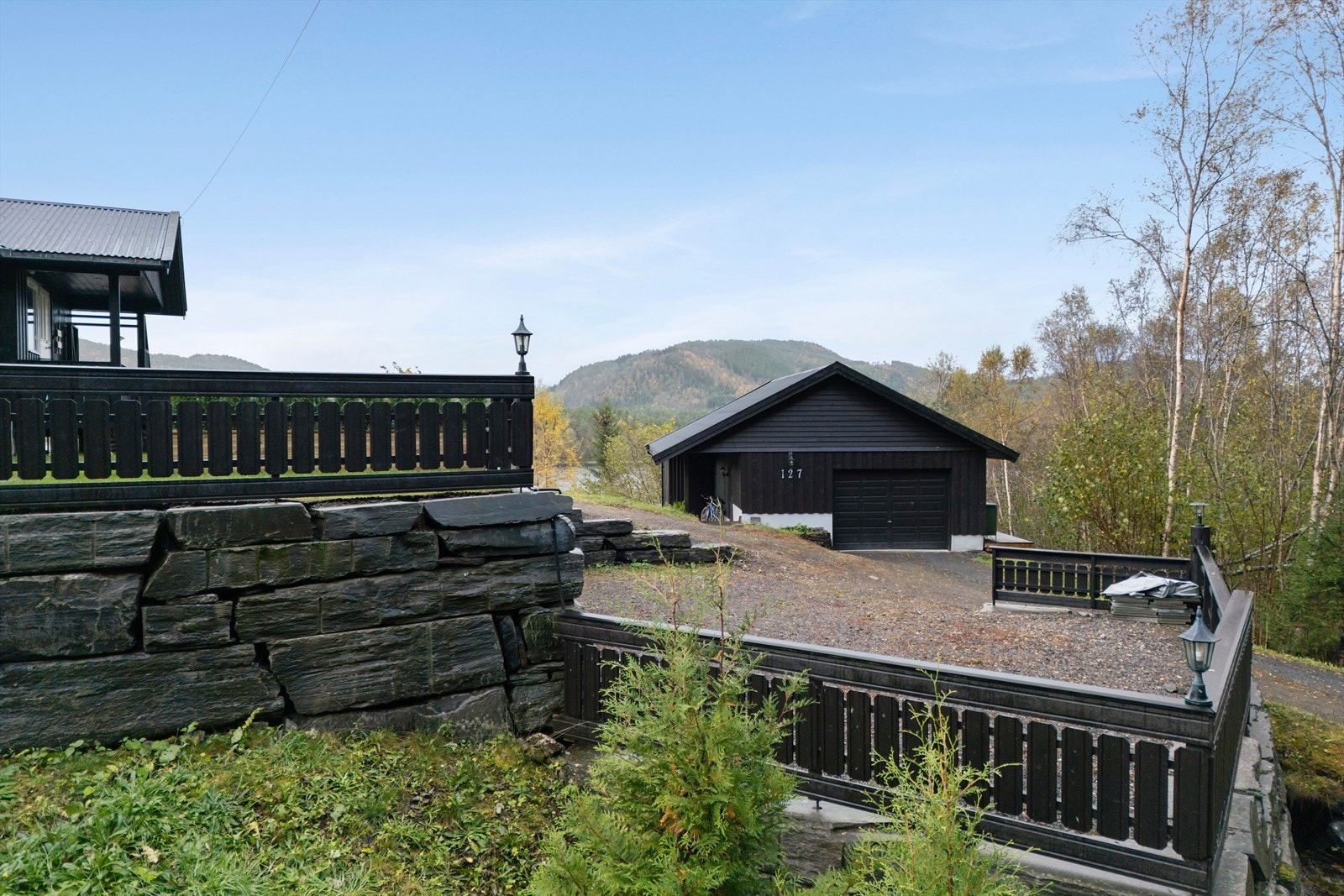 Gårdsplassen har stor oppstillingsplass til bil og en frittstående garasje. Galleribilde