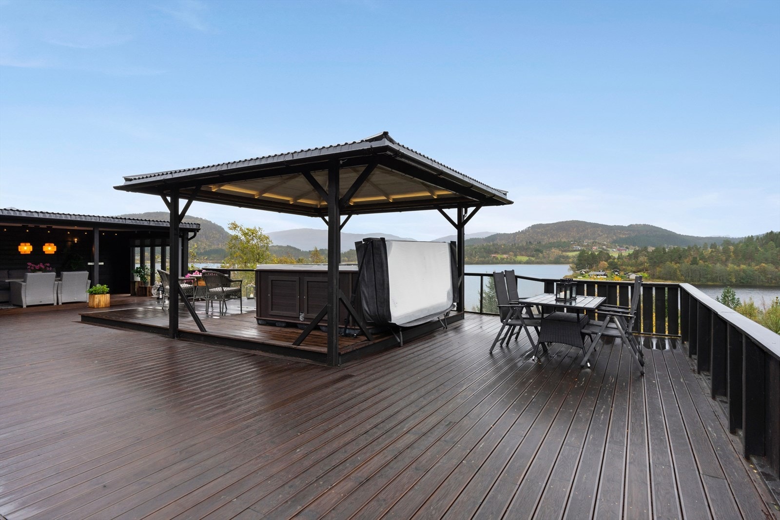 Den romslige terrassen gir plass til flere sittegrupper og med overbygd jacuzzi blir plassen perfekt for avslapning. Galleribilde