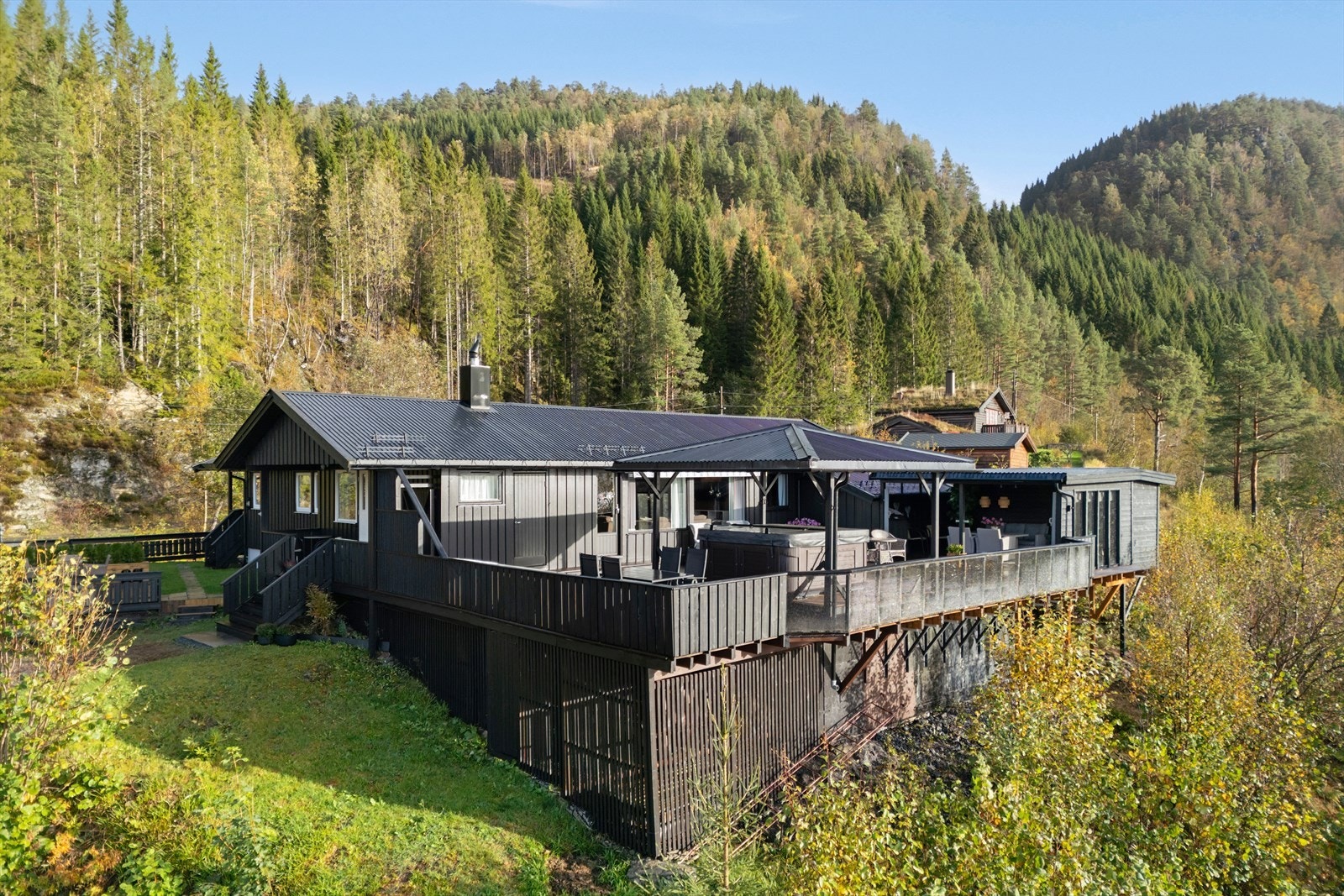 Boligen er omkranset av frodig natur og har en terrasse som strekker seg rundt store deler av boligen. Galleribilde