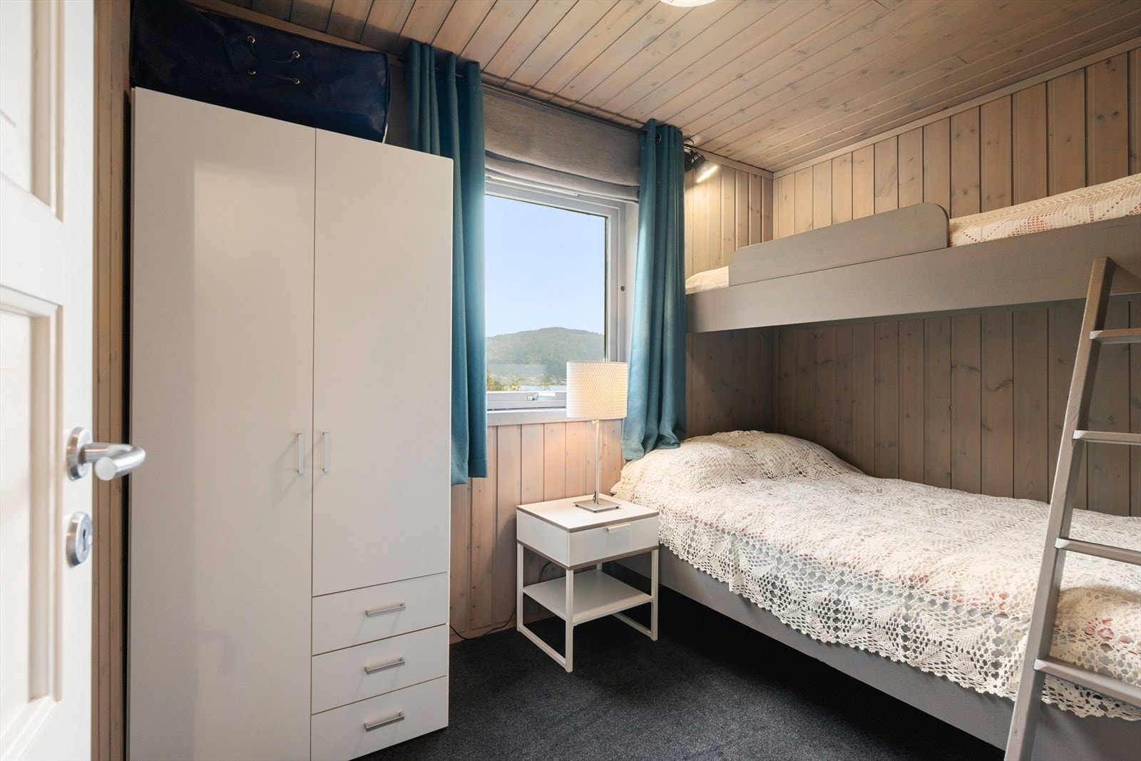 Soverom med plassbesparende køyesenger og et stort vindu som gir naturlig lys. Galleribilde