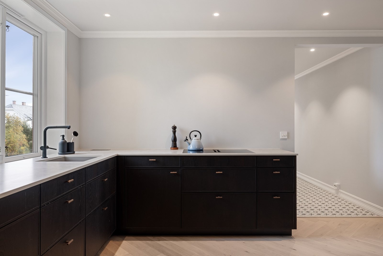 Benkeplate i kompositt med nedfelt oppvaskkum med ett-greps blandebatteri. Det er også integrerte stikkontakter i benkeplaten. Galleribilde