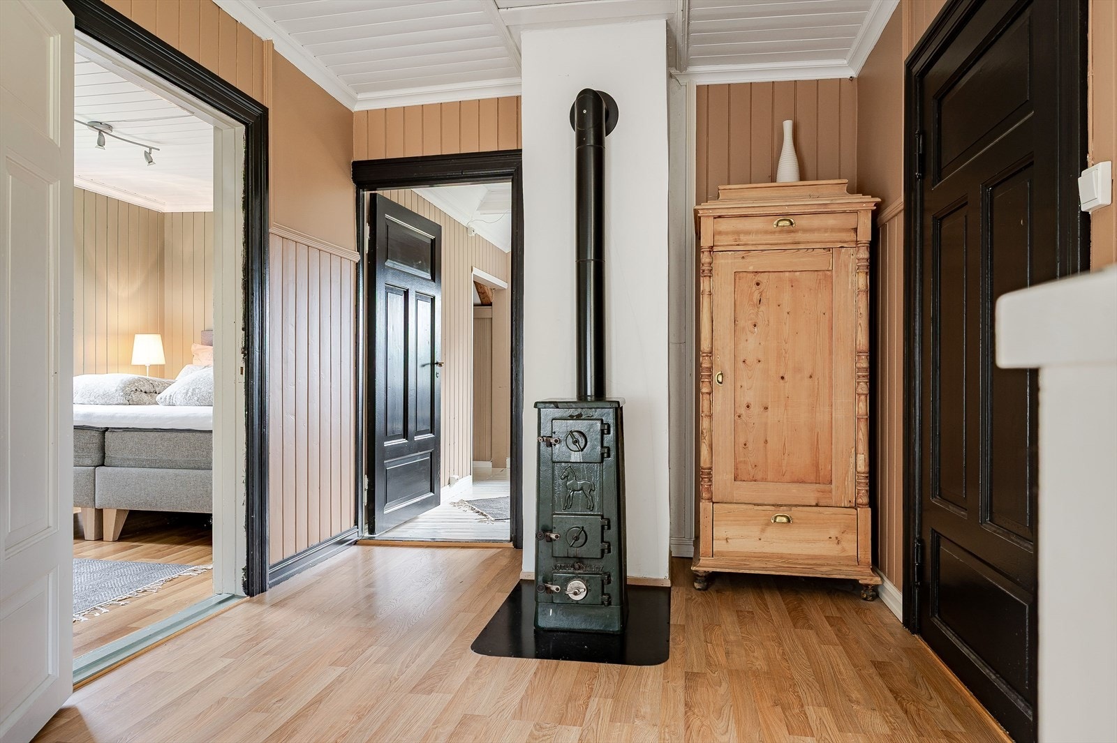 Gang/trapperom i 2. etasje med adkomst til 3 soverom, baderom og 2 boder/garderober. Som et fint midtpunkt i gangen er det en sjarmerende eldre koksovn. Galleribilde