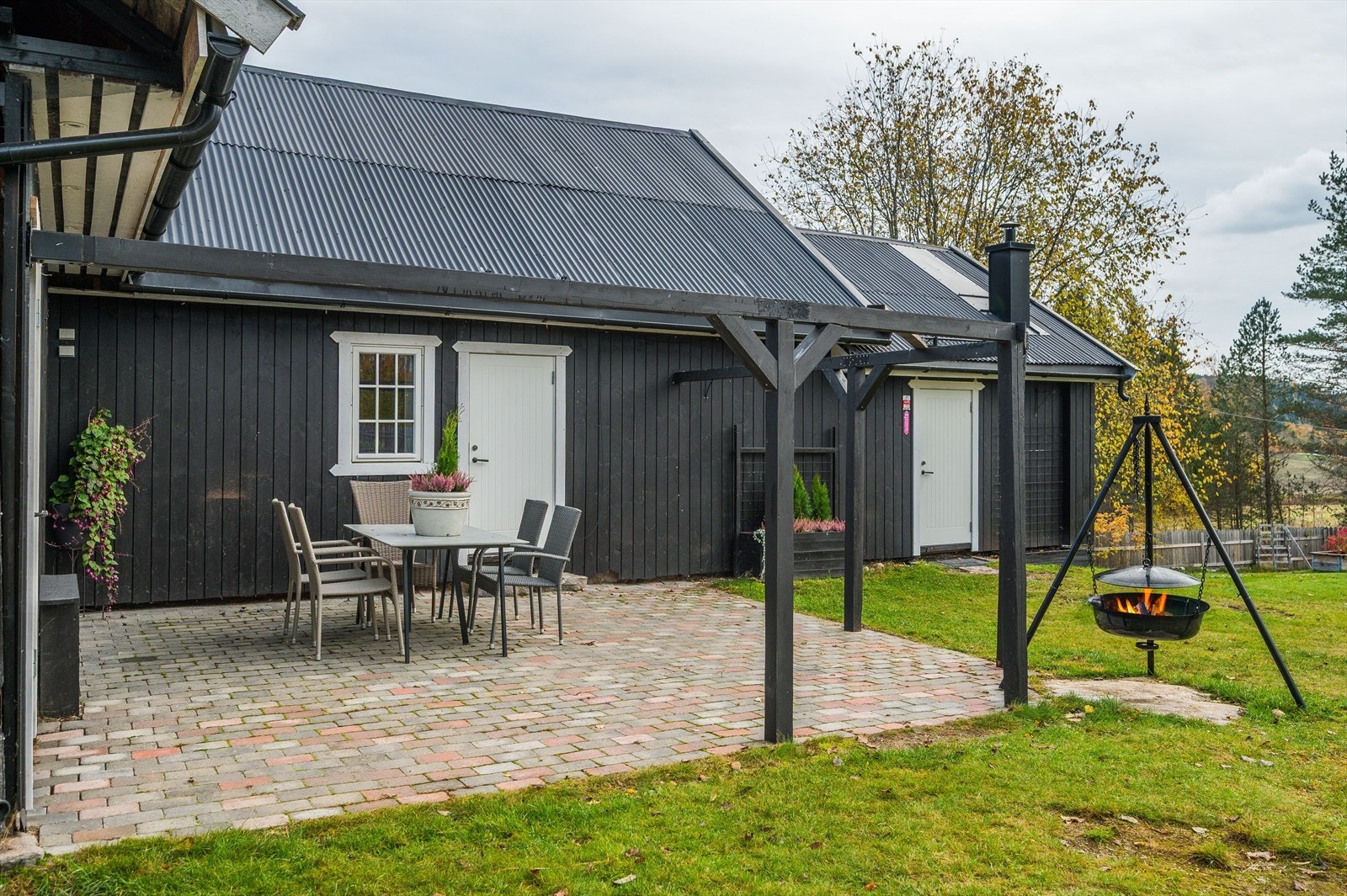 Utenfor låven er det opparbeidet en uteplass med belegningsstein og bålpanne. Galleribilde