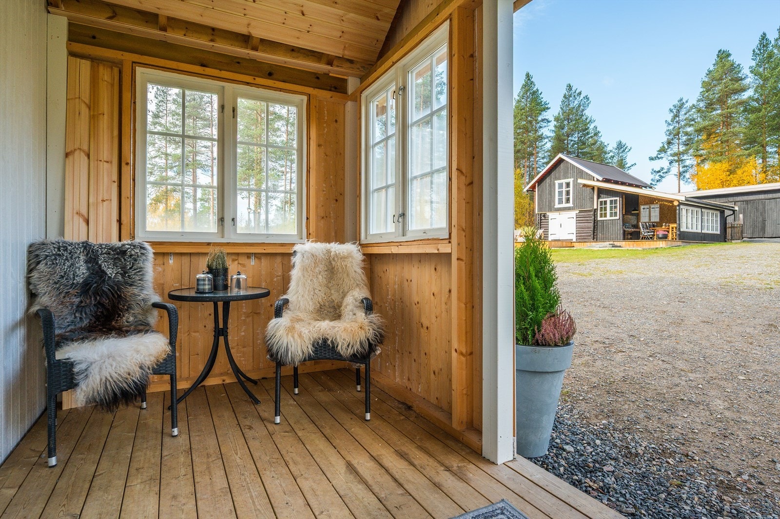 Overbygget inngangsparti fra 2024-25. Gulvflate med Cu-impregnerte terrassebord og stående kledning med sjarmerende eldre vinduer. Galleribilde