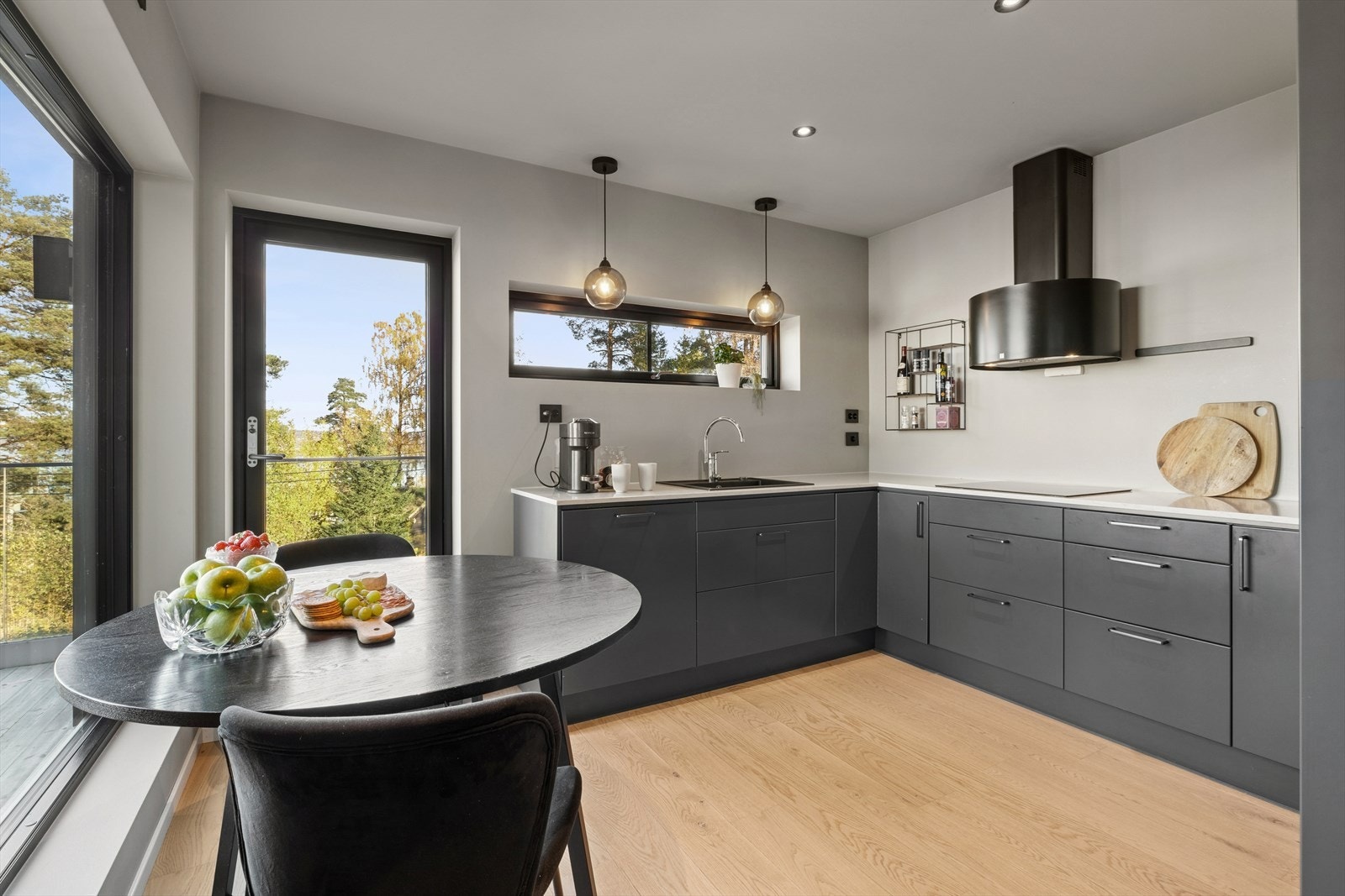 Lekkert kjøkken med slette fronter og benkeplate i stein med nedfelt vaskekum. Galleribilde