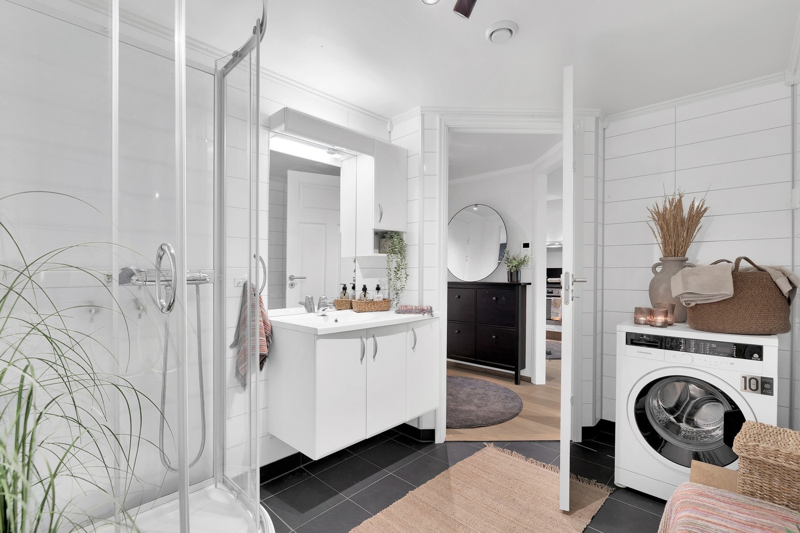 Badet har dusjkabinett, servant med god oppbevaringsplass og opplegg for vaskemaskin. Galleribilde