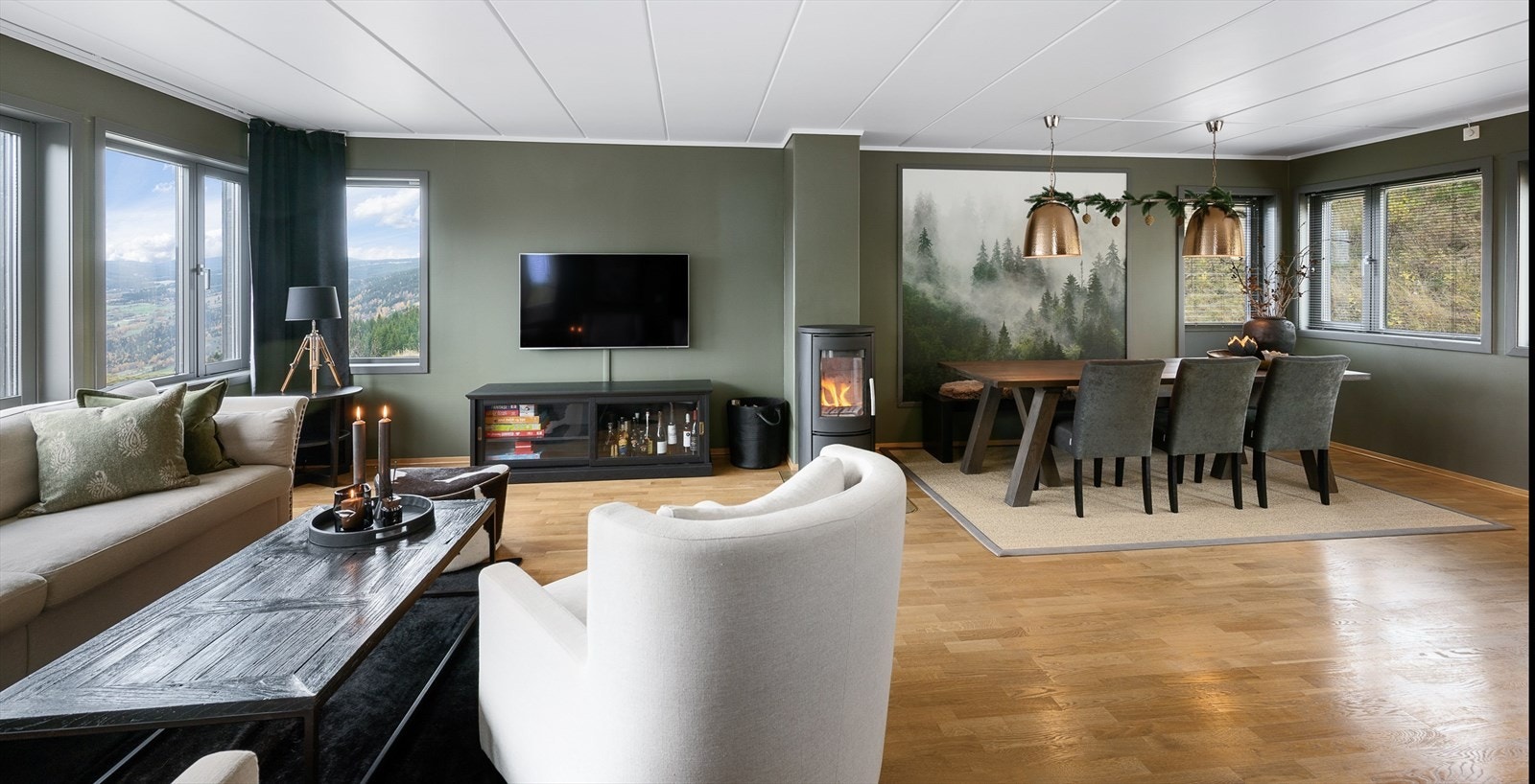 Stue og kjøkken i åpen løsning. Rommet har vinduer på tre av veggene, som slipper inn rikelig med sollys. Galleribilde