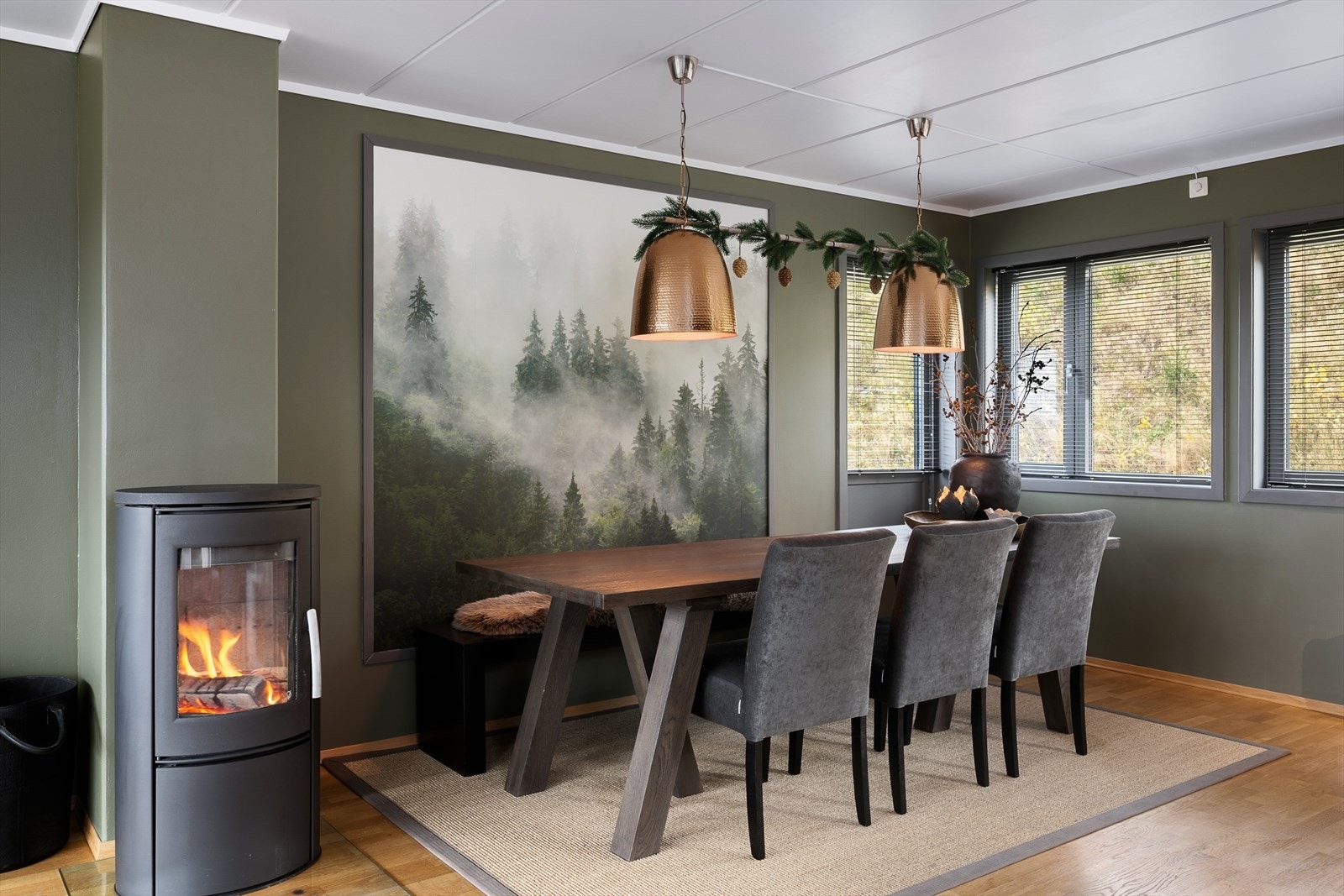 Vedovnen er strategisk plassert mellom sofakroken og spiseplassen. Det er utgang til uteplass i enden av rommet. Galleribilde