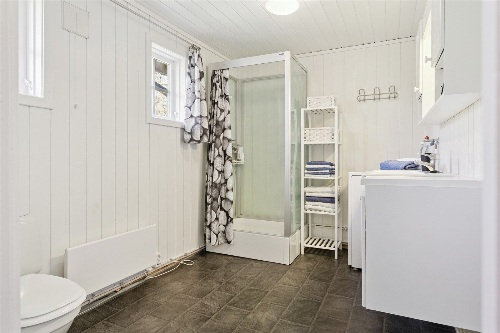 - Bad innredet med toalett, dusjkabinett, servantmøbel og opplegg for vaskemaskin - Galleribilde