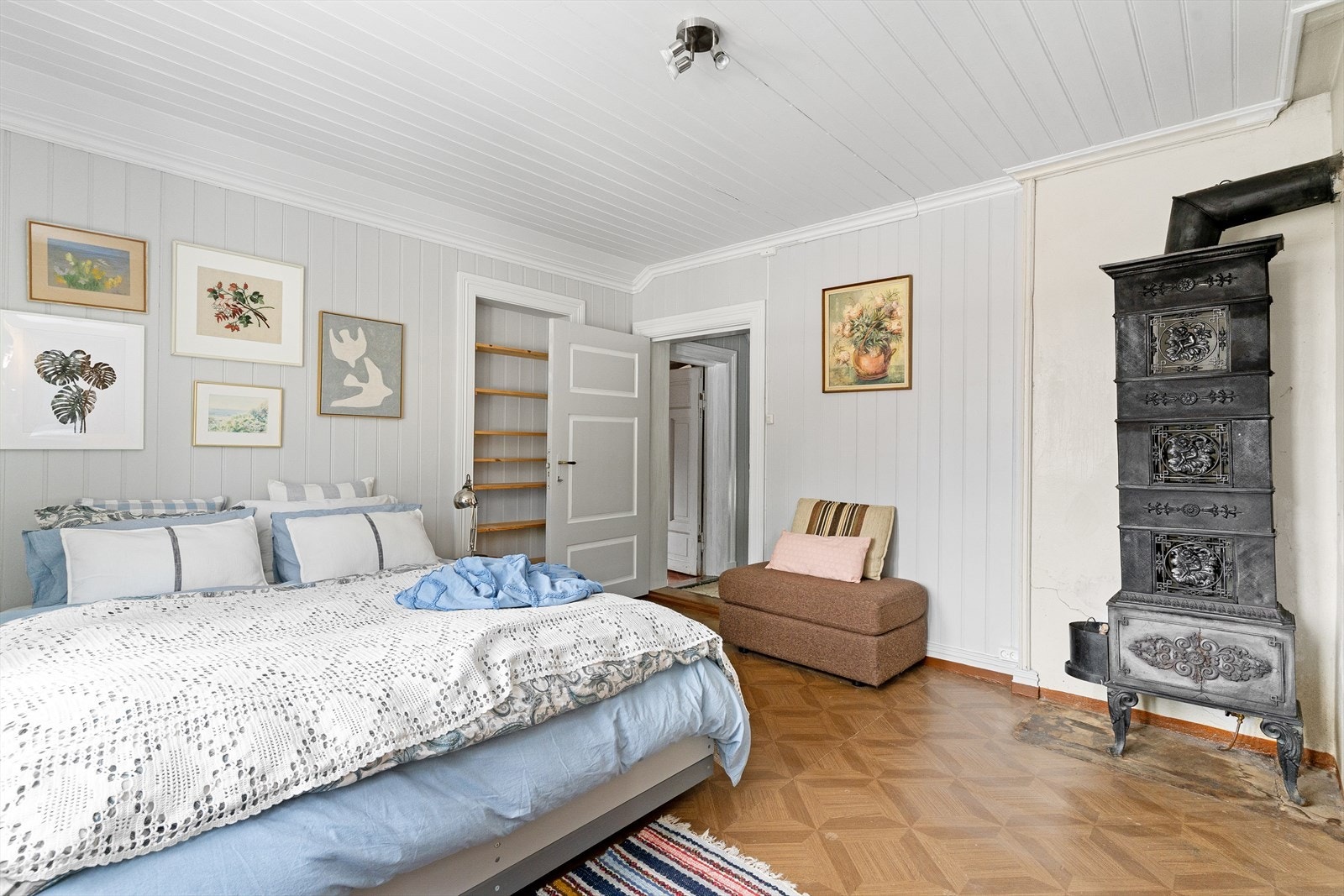 En lekker etasjeovn står bevart i hjørnet av rommet. Galleribilde