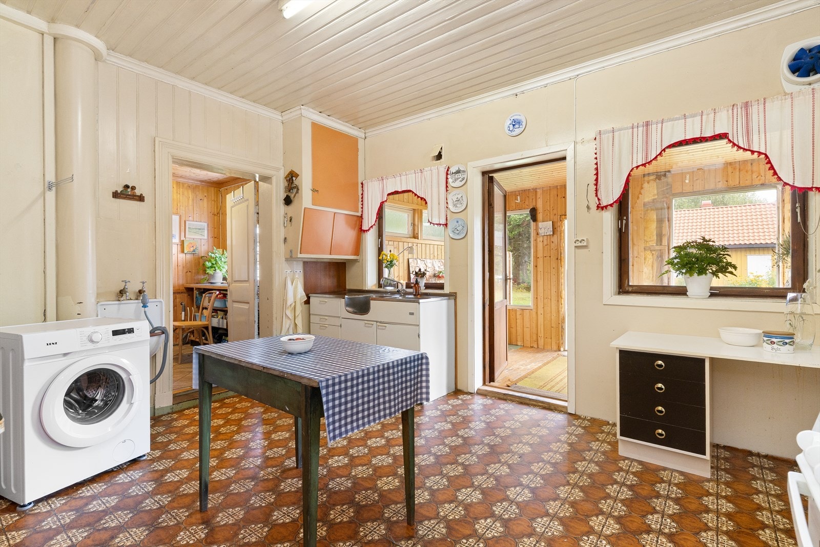 Fra kjøkkenet har man tilgang ut på tunet, gjennom en innbygget gang under terrassen i andre etasje. Galleribilde