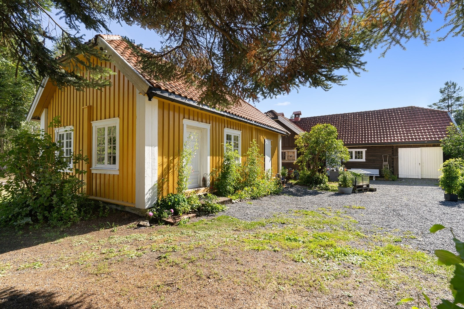 De ulike byggene på tomta gir en lun og idyllisk tunfølelse. Med god boltreplass for diverse hobbyer og prosjekter, små og store. Galleribilde