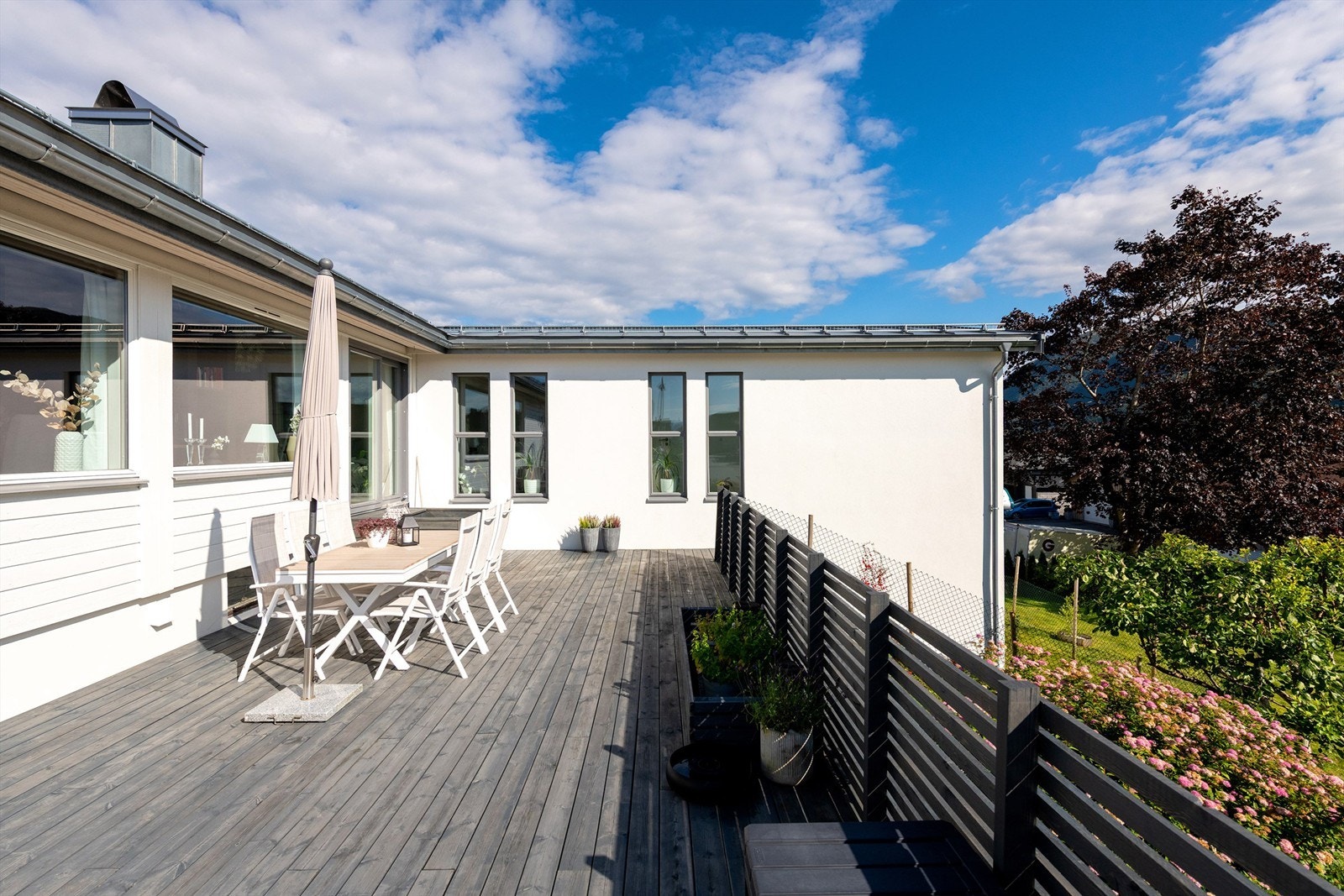 Stor terrasse med god plass til flere soner og sitteplasser - trapp herfra til hage Galleribilde