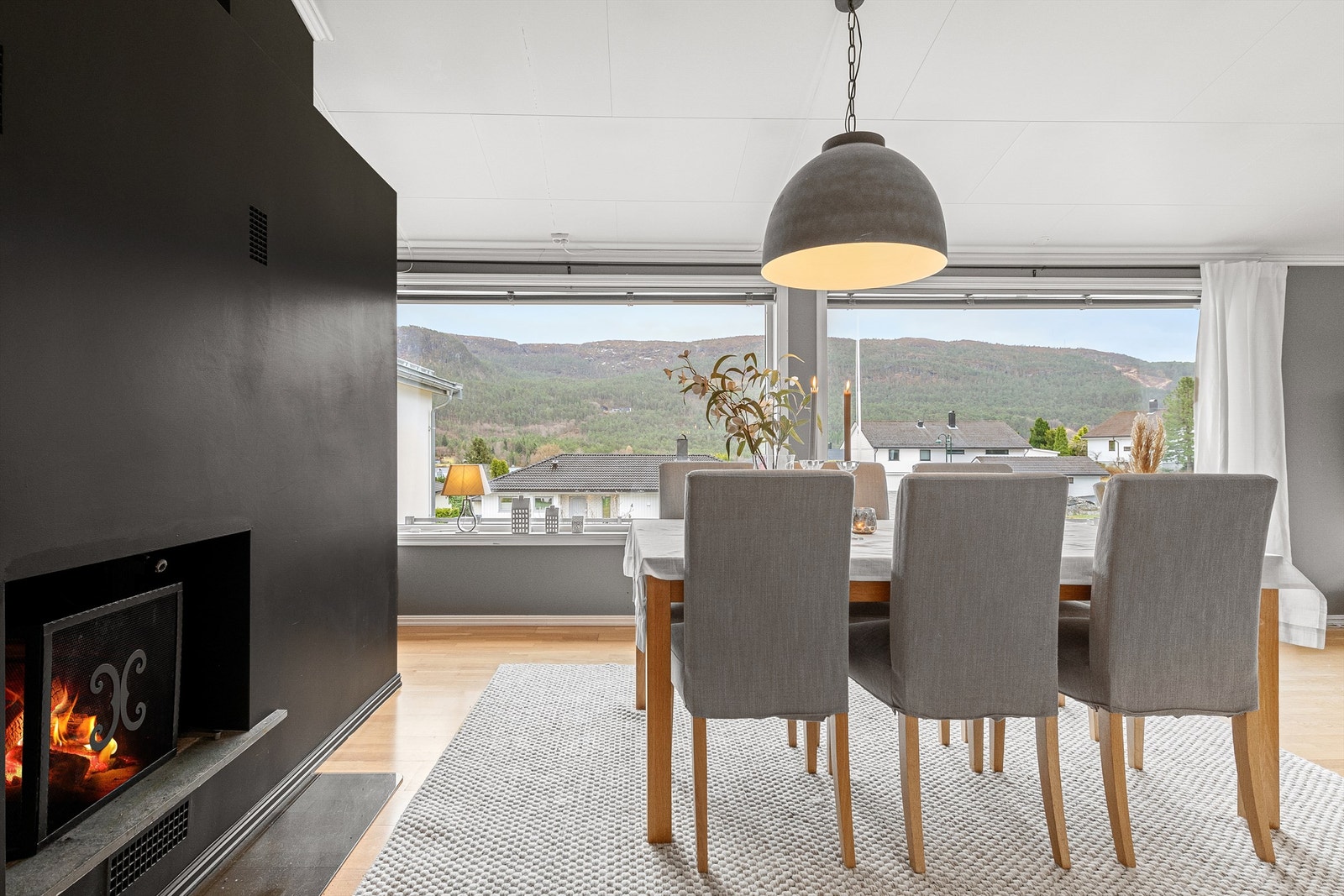 Åpen murt peis på stuen som gir en lun og hyggelig atmosfære Galleribilde