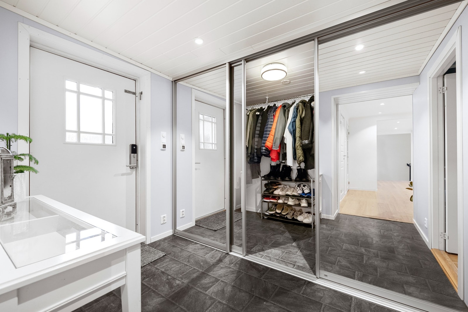 Det er store skyvedørsfronter til garderoberom med svært gode oppbeværingsmuligheter for yttertøy og sko Galleribilde