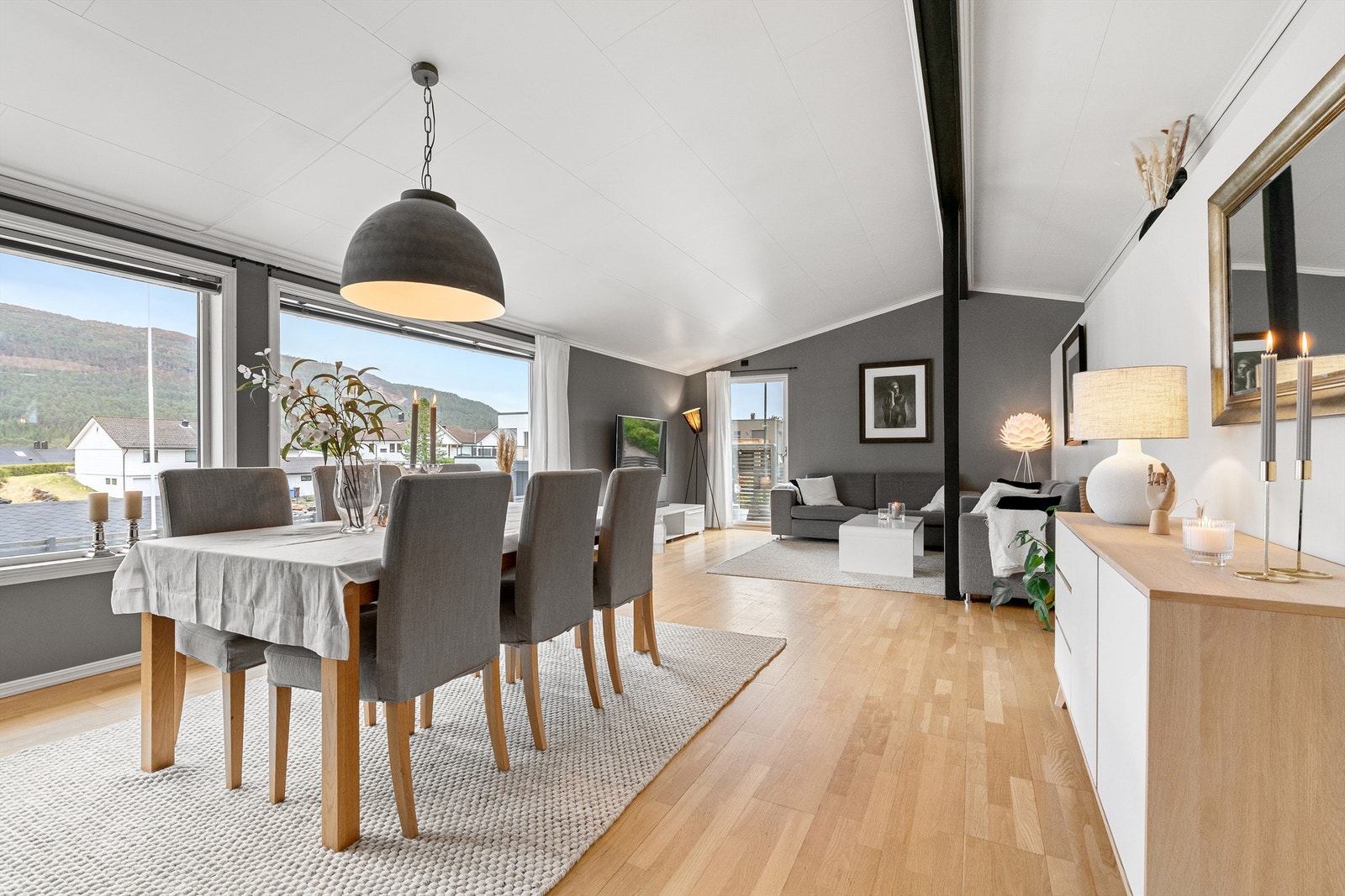 Stue med lyse overflater og godt med lysinnslipp fra store vindusflater mot syd. Åpen himling og god takhøyde Galleribilde