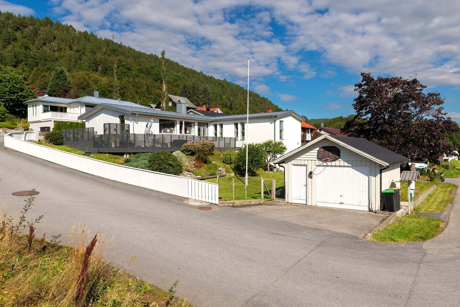 Fasade, hage og garasje sett fra adkomtveg Galleribilde