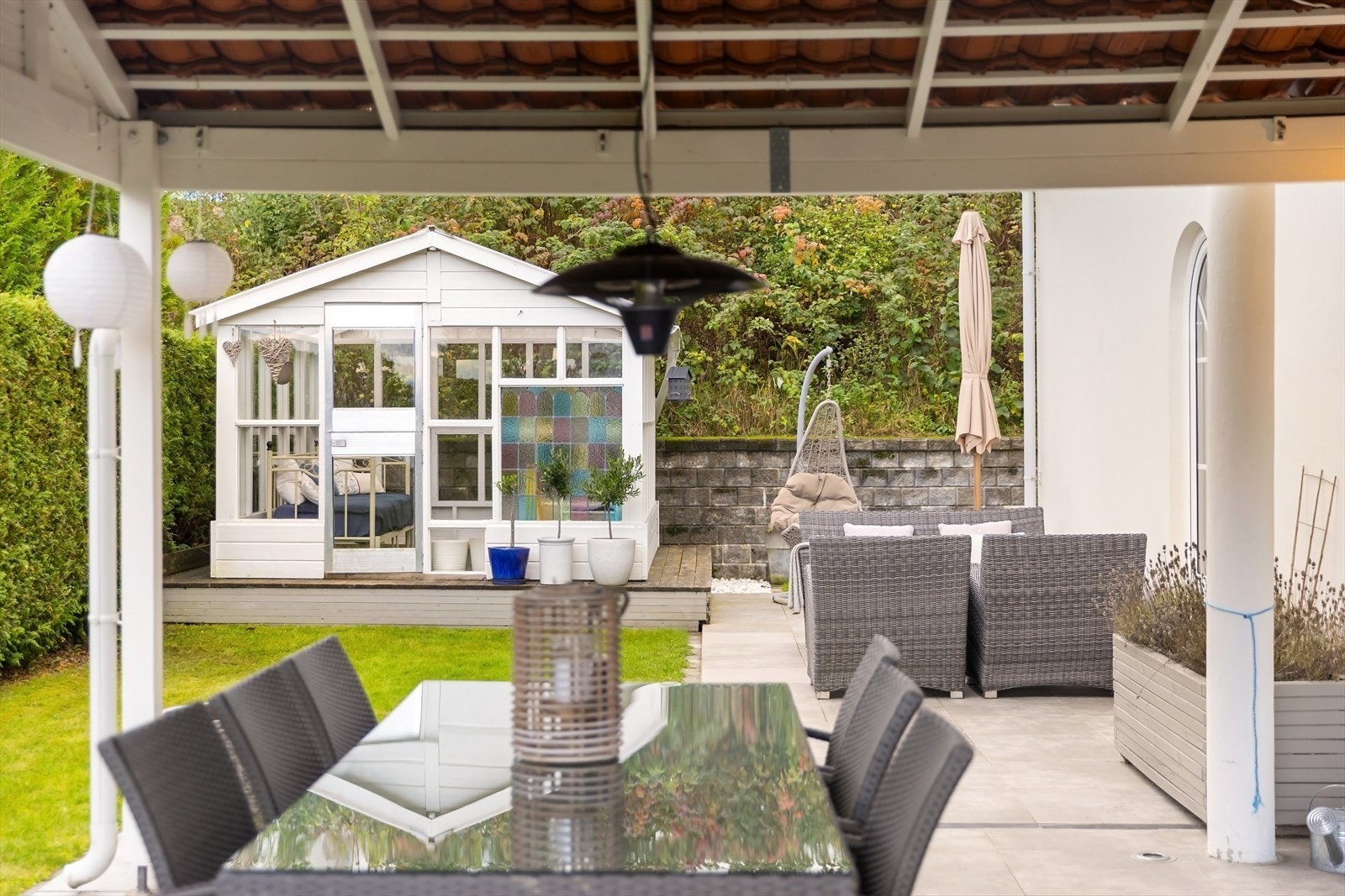 Terrassen strekker seg rundt to sider av boligen. Galleribilde