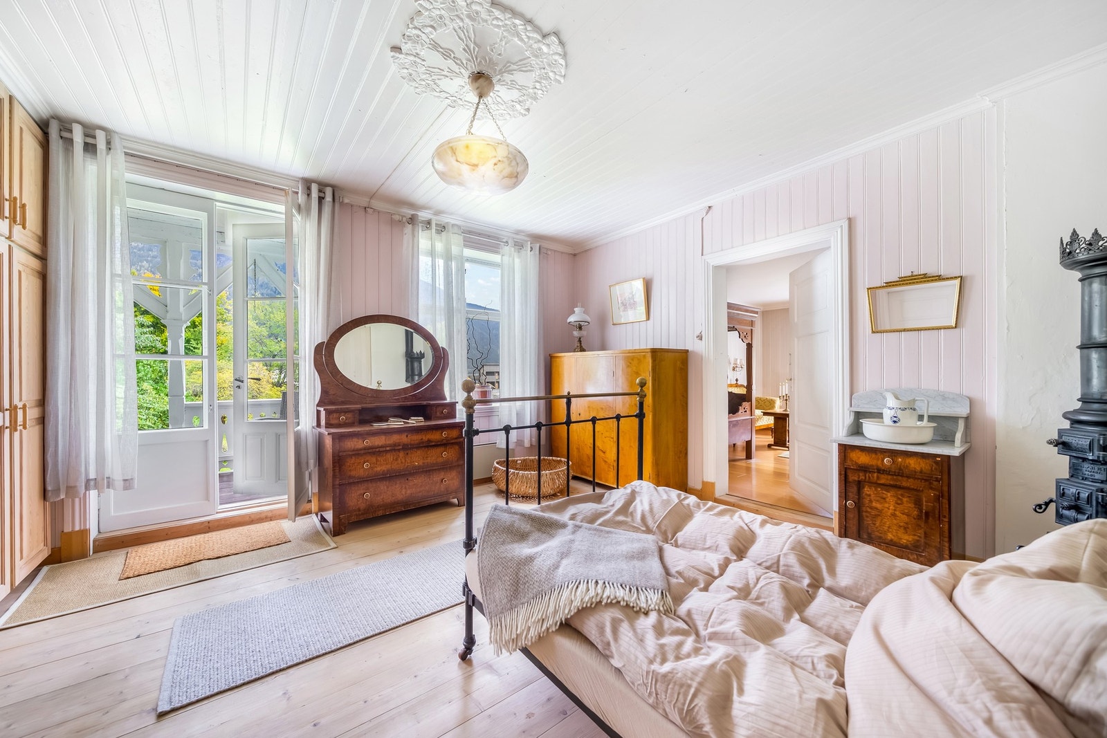 Romslig soverom med utgang til overbygget terrasse gjennom gamle glassdører. Trapp fører videre ned til hagen - en idyllisk forbindelse mellom inne og ute. Galleribilde