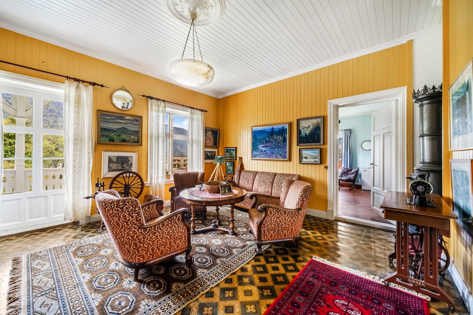 Lys og innbydende verandastue med flotte mønstrede overflater og dekorativ etasjeovn. Galleribilde