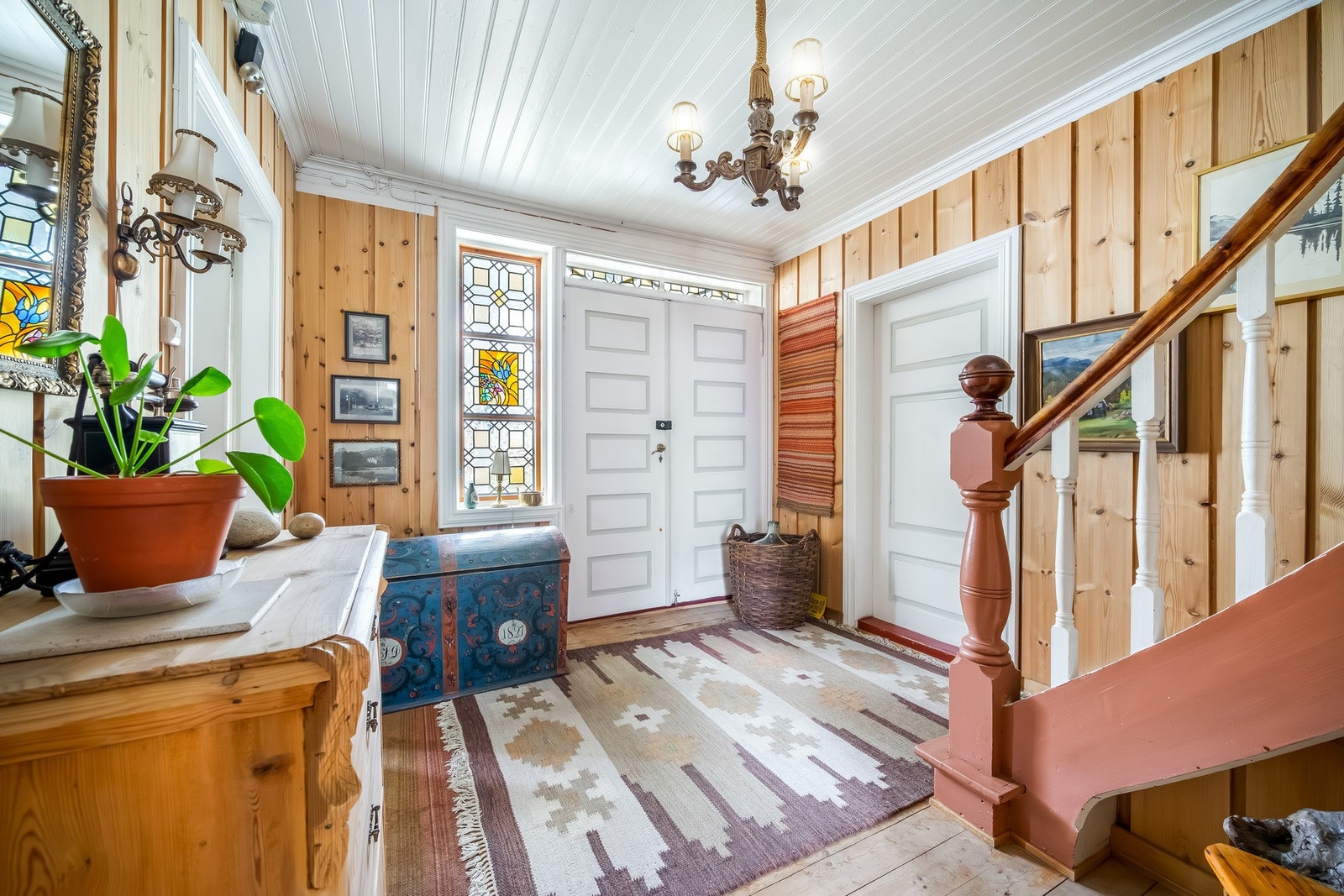 Velkommen inn i en romslig entré med original trapp i tre og vakre detaljer som vitner om husets historie. Galleribilde