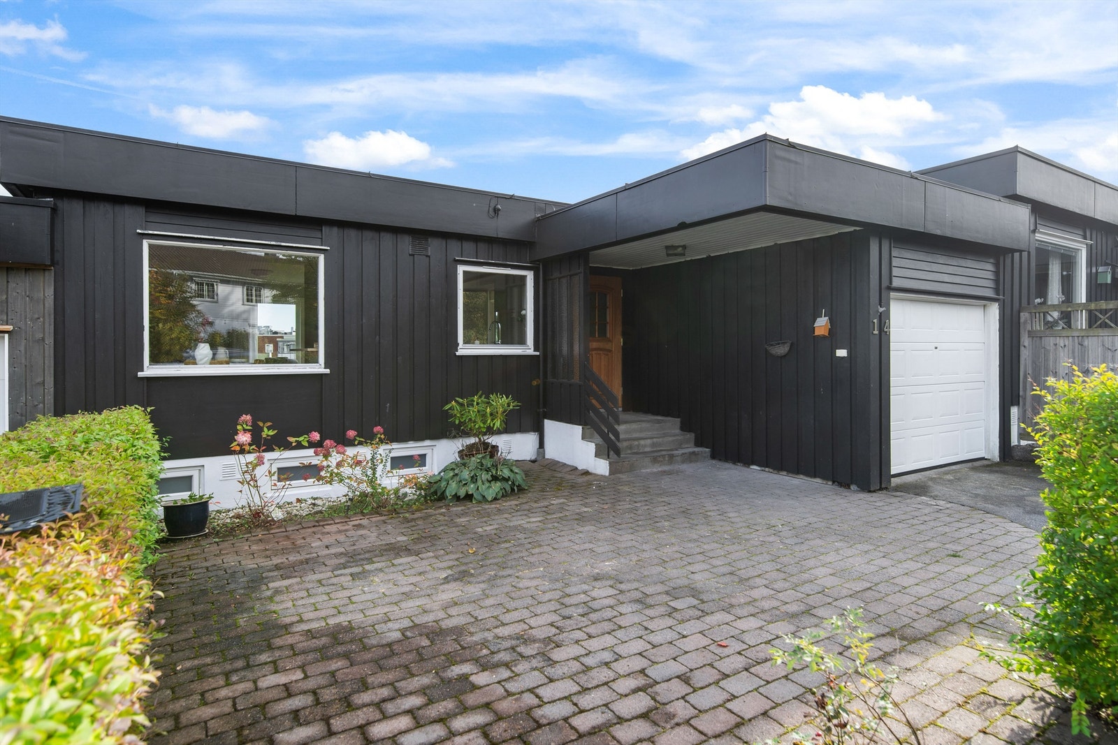 Et fint steinlagt område på fremsiden av boligen med plass til enten bil eller sittegruppe Galleribilde