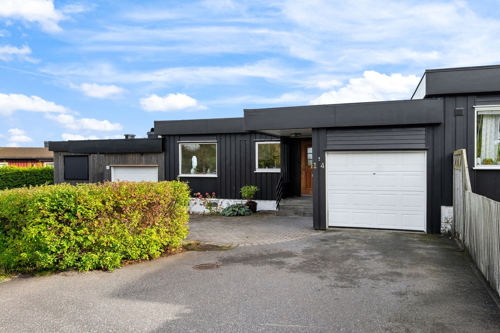 Fasade inngangsparti med garasje og biloppstillingsplasser Galleribilde