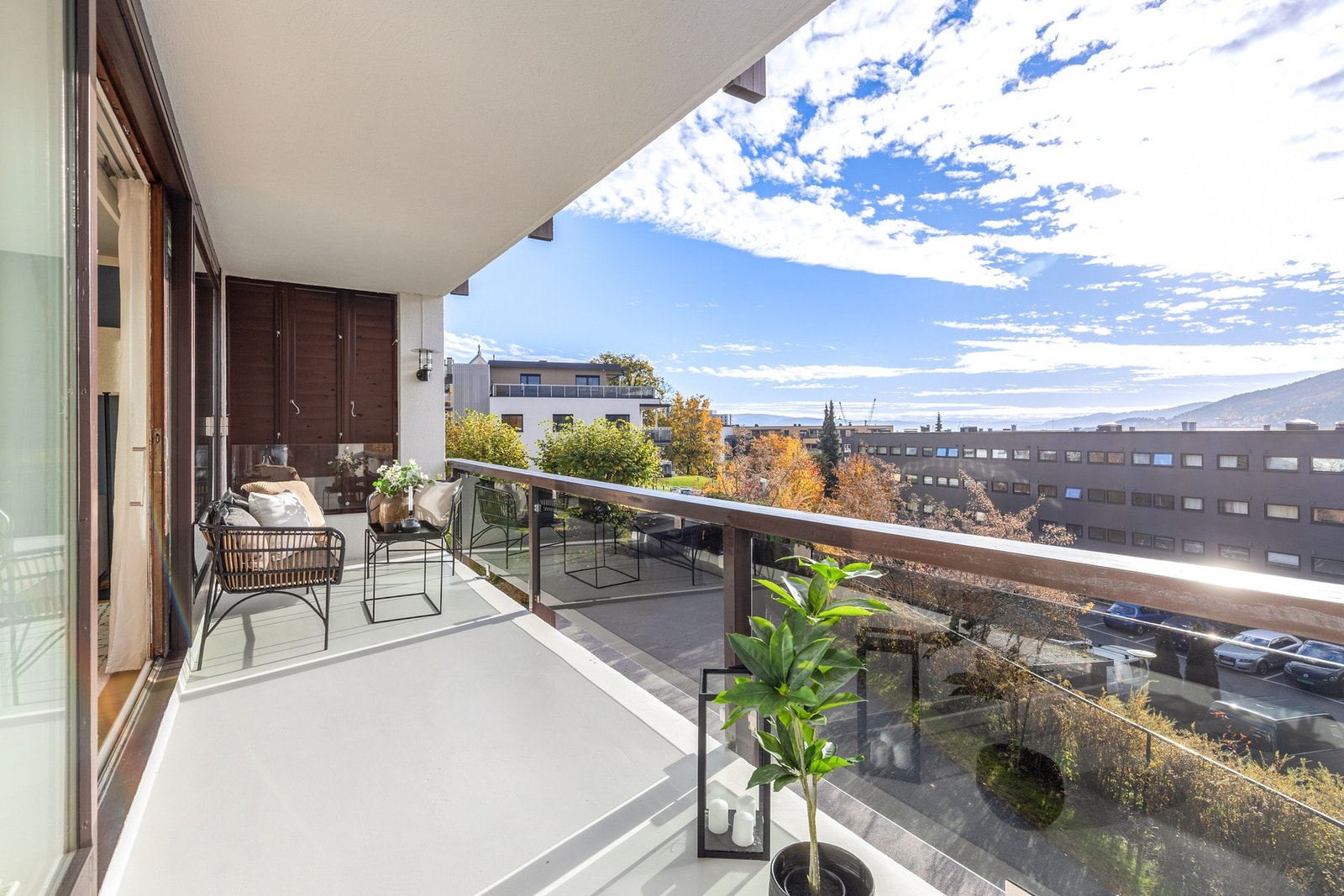 Balkongen er takoverbygget og har rekkverk i trevirke og glass Galleribilde