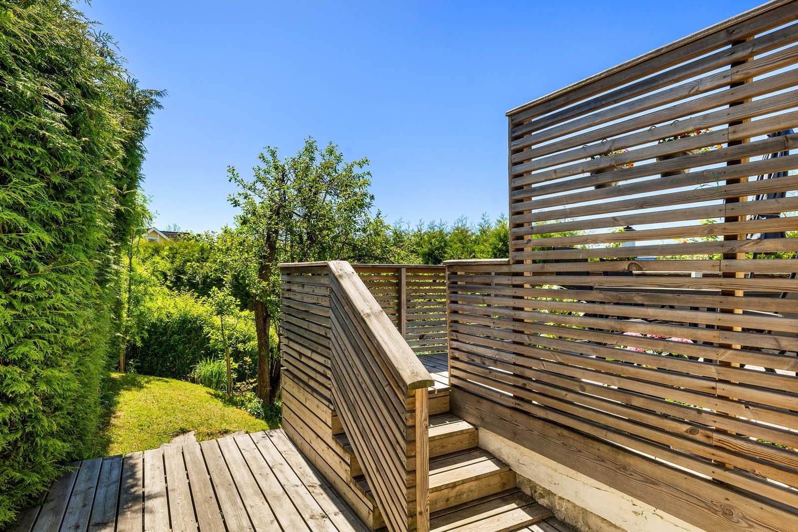Terrassens åpning mot hagen gir en harmonisk overgang til naturen utenfor. Galleribilde