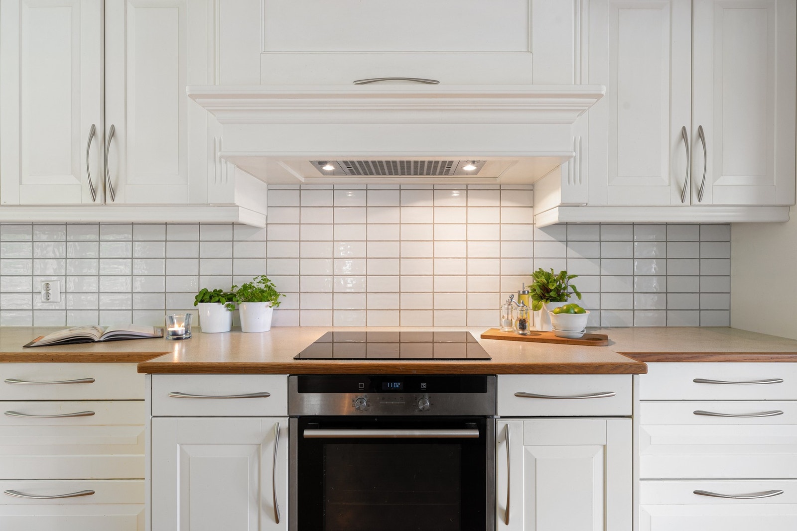 Laminerte benkeplater og flislagt vegg mellom benk og overskap gir et tidløst og praktisk uttrykk. Galleribilde