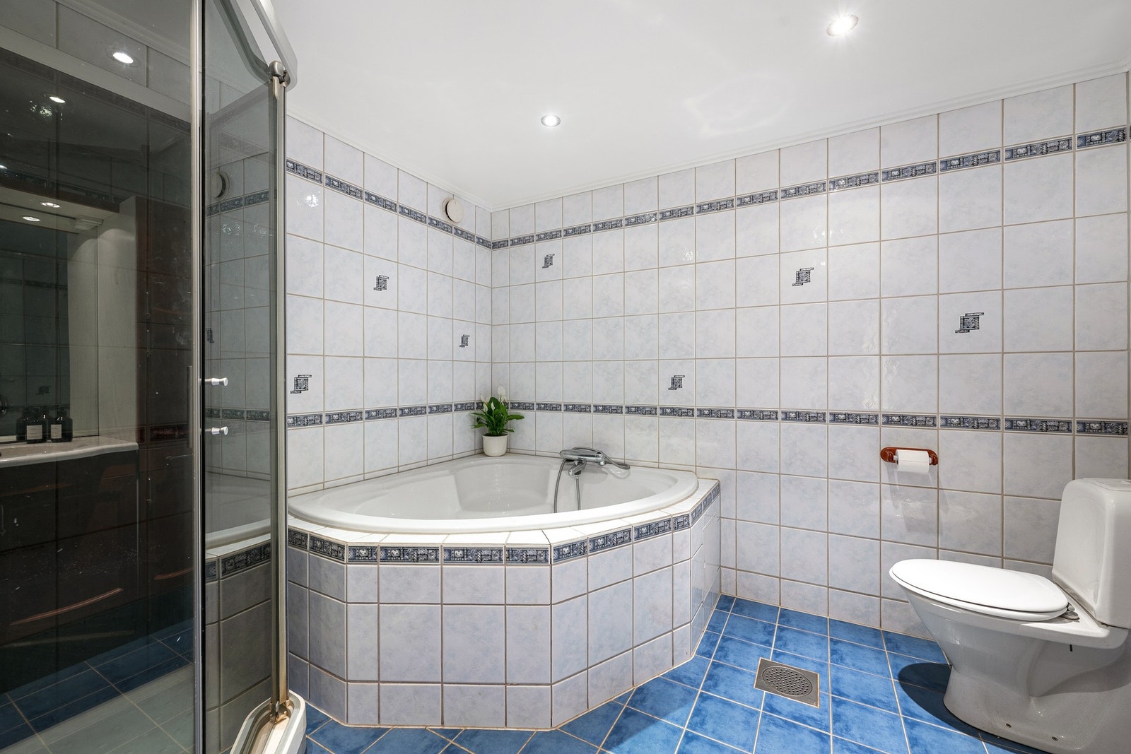 Her er det flislagt gulv med behagelig gulvvarme, dusjkabinett og et innbygget badekar. Galleribilde