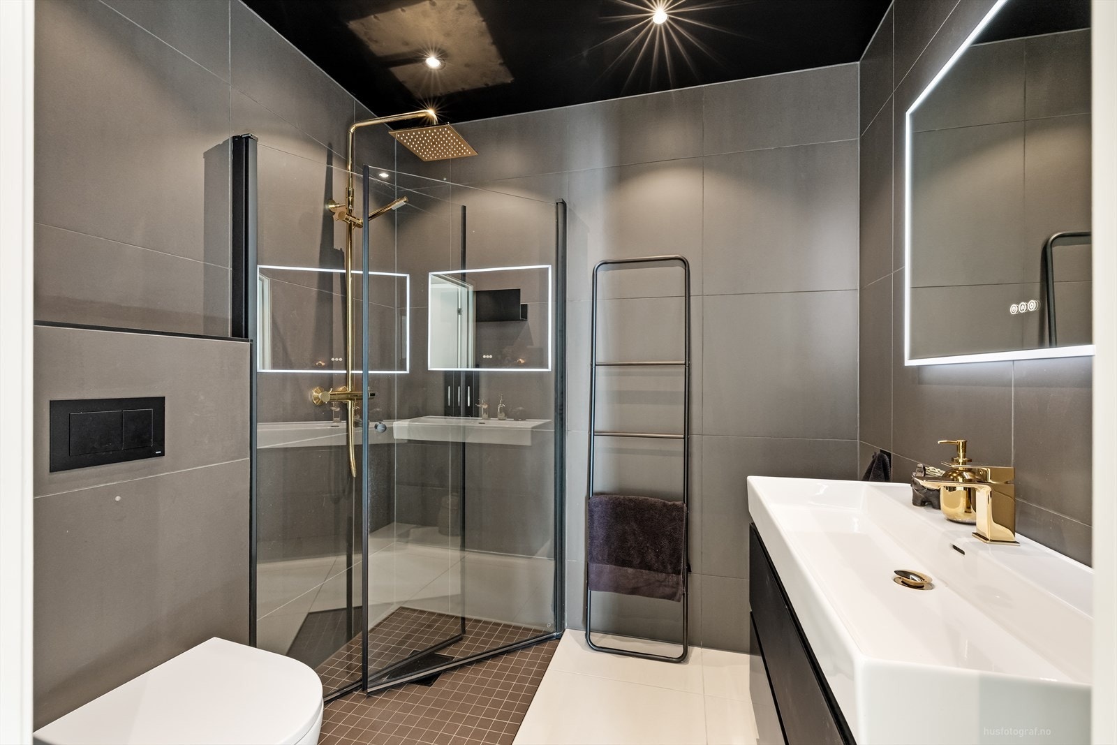 Badet har dusjhjørne, vegghengt toalett og servant med underskap. Galleribilde