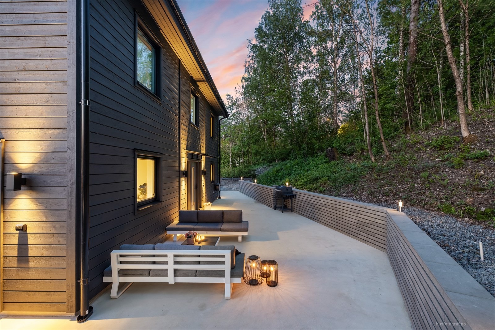 Bak huset er det også opparbeidet med terrasse og behagelig lyssetting. Galleribilde